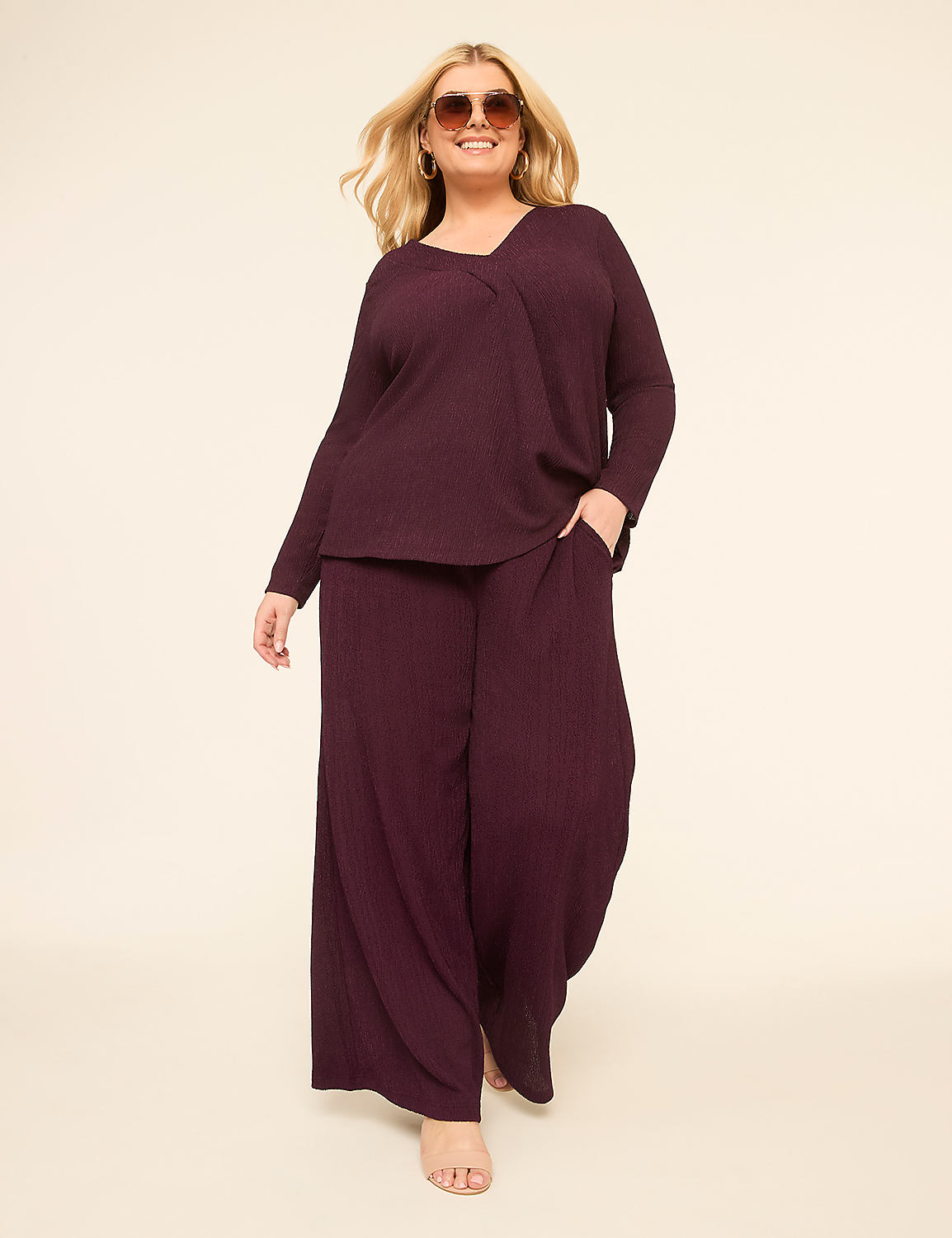 A smiling woman in a burgundy ribbed loungewear set stands against a plain cream background. Product Image 3