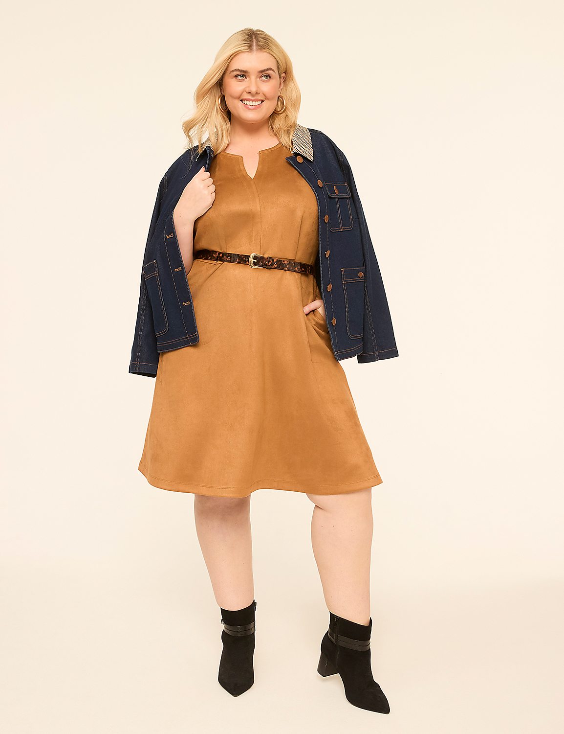 A woman in a tan dress and denim jacket stands against a plain, light background. Product Image 1