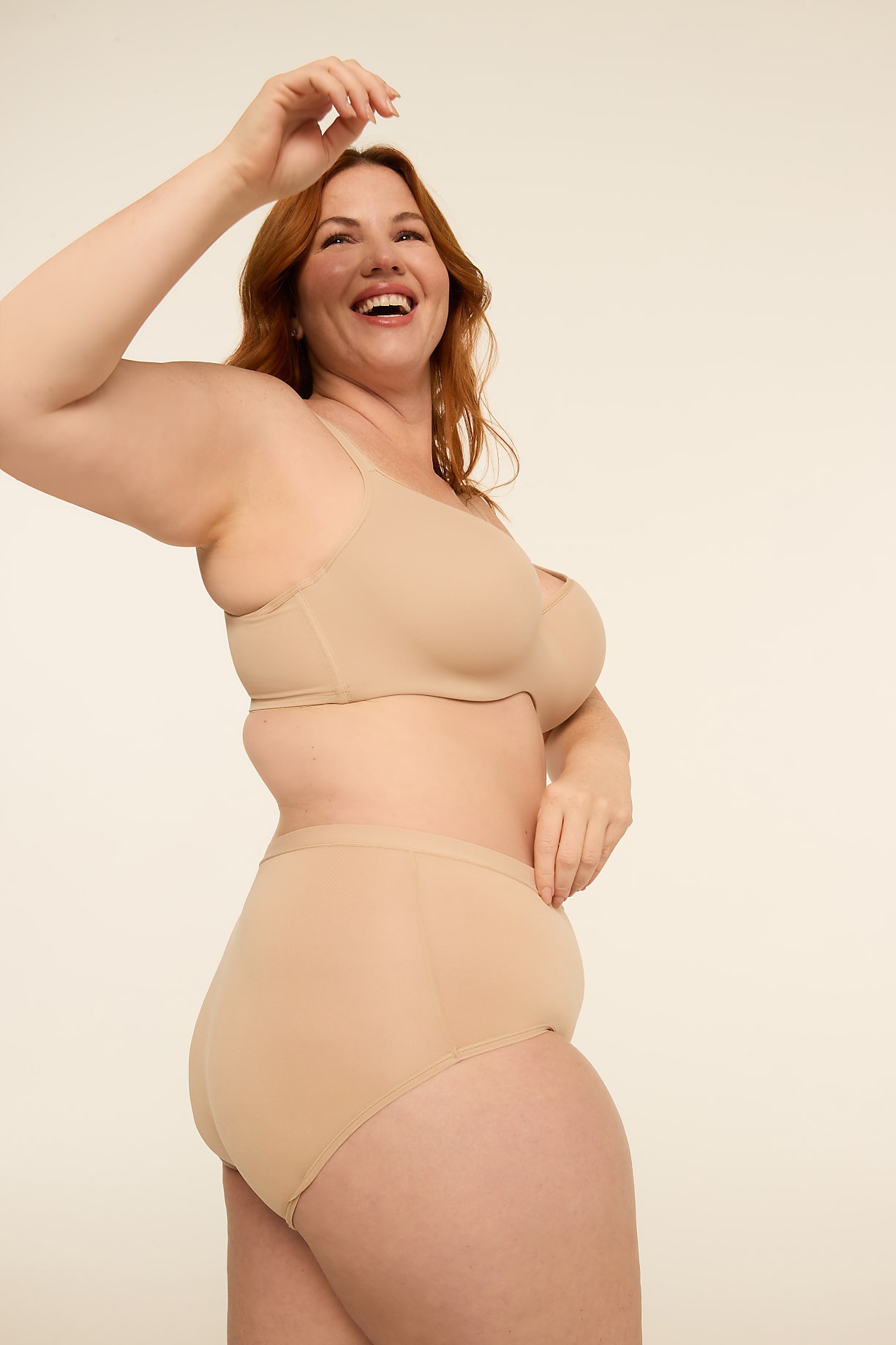 A smiling woman with red hair in a beige bra and high-waisted underwear poses against a plain, light background. Product Image 8
