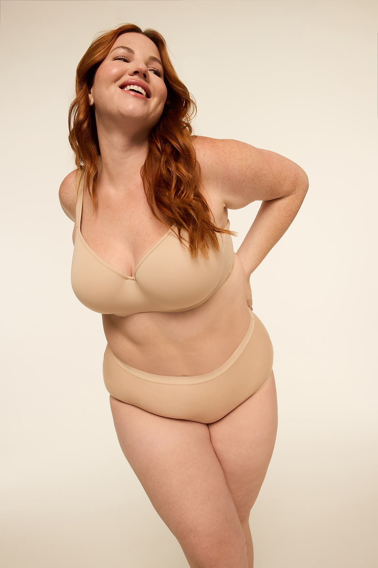 A smiling woman with red hair in a beige bra and underwear stands against a plain, light background. Product Image 10