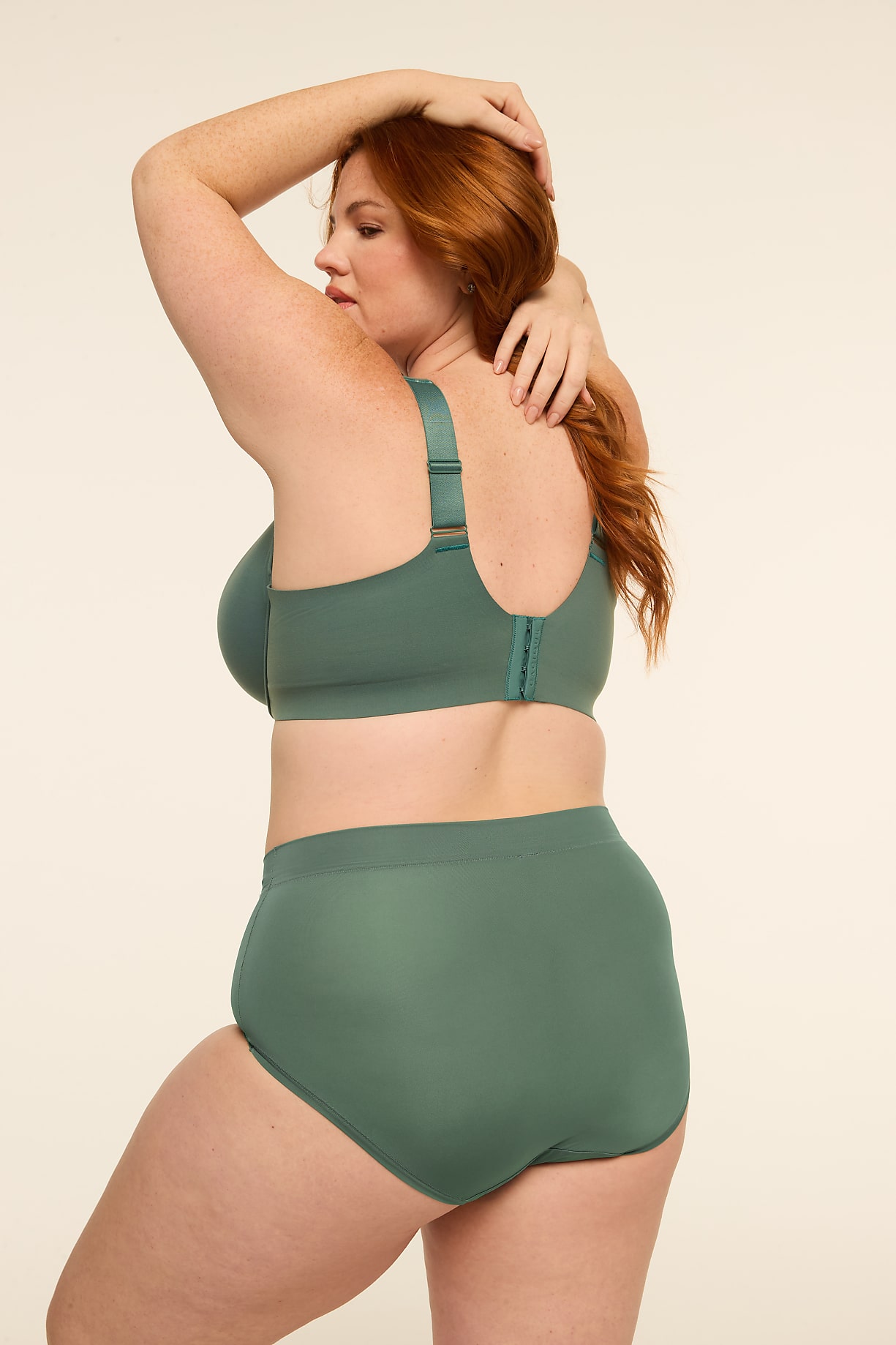 A woman with red hair poses in a green bra and underwear against a plain, light-colored background. Product Image 8