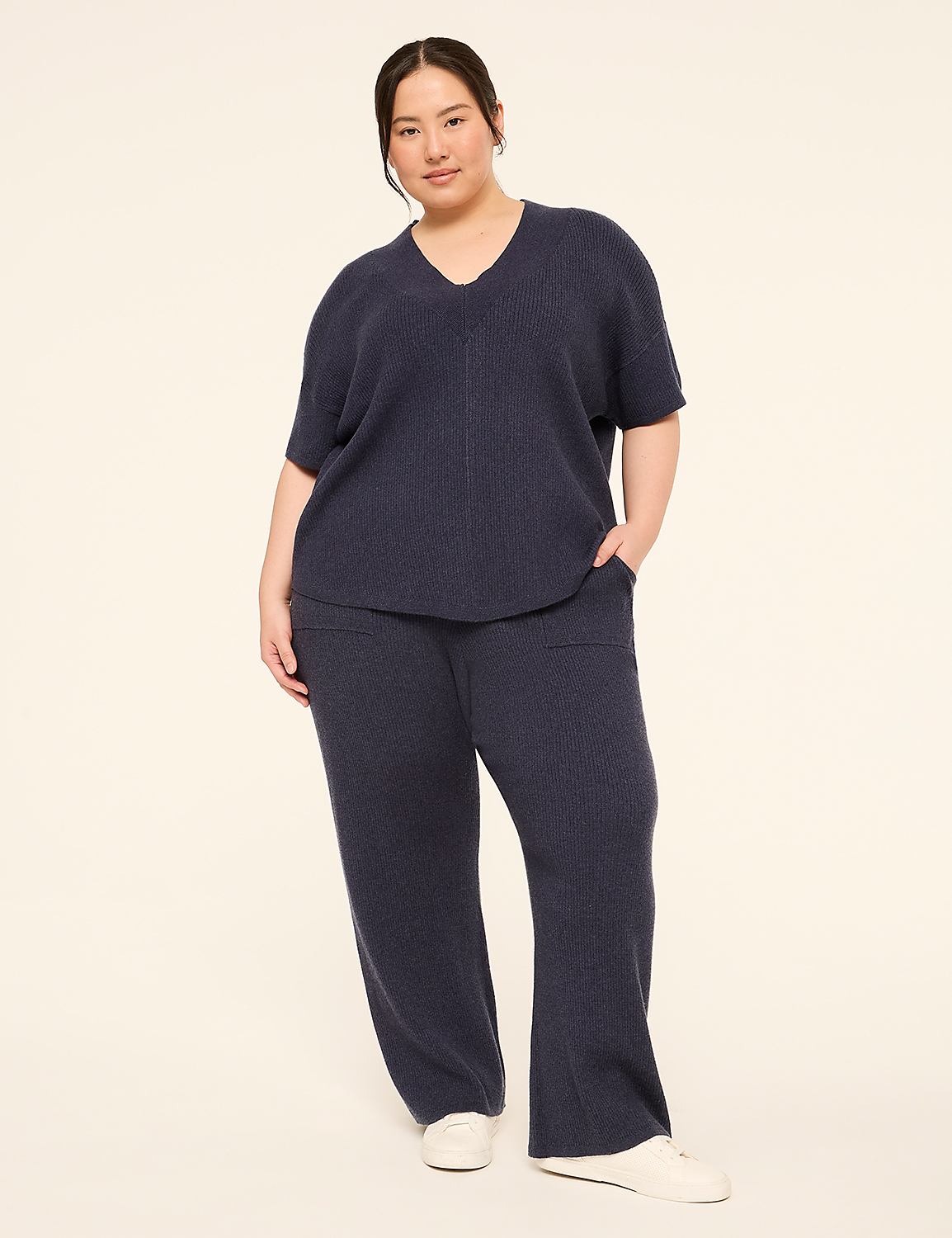 A woman in a navy blue loungewear set stands against a plain, light-colored background. Product Image 3