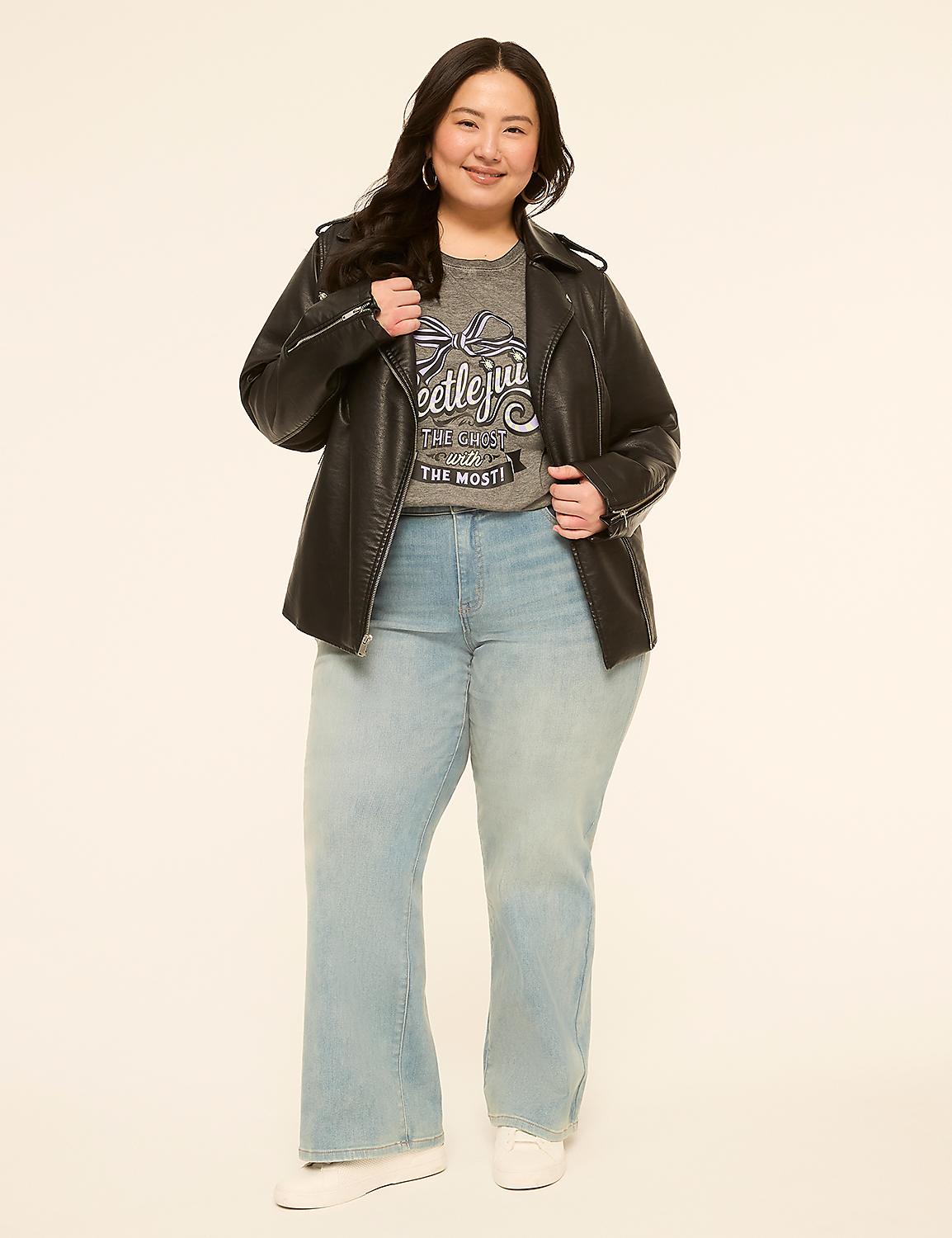 A woman in a Beetlejuice t-shirt, black leather jacket, and light-wash jeans stands against a plain, light-colored background. Product Image 3