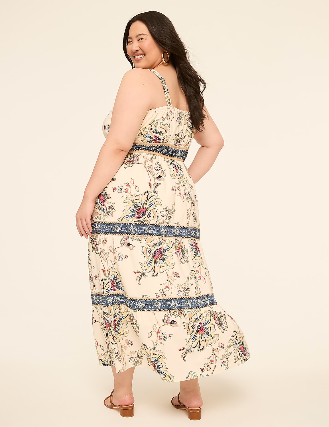 A woman in a floral print dress stands against a plain, light-colored background. Product Image 2