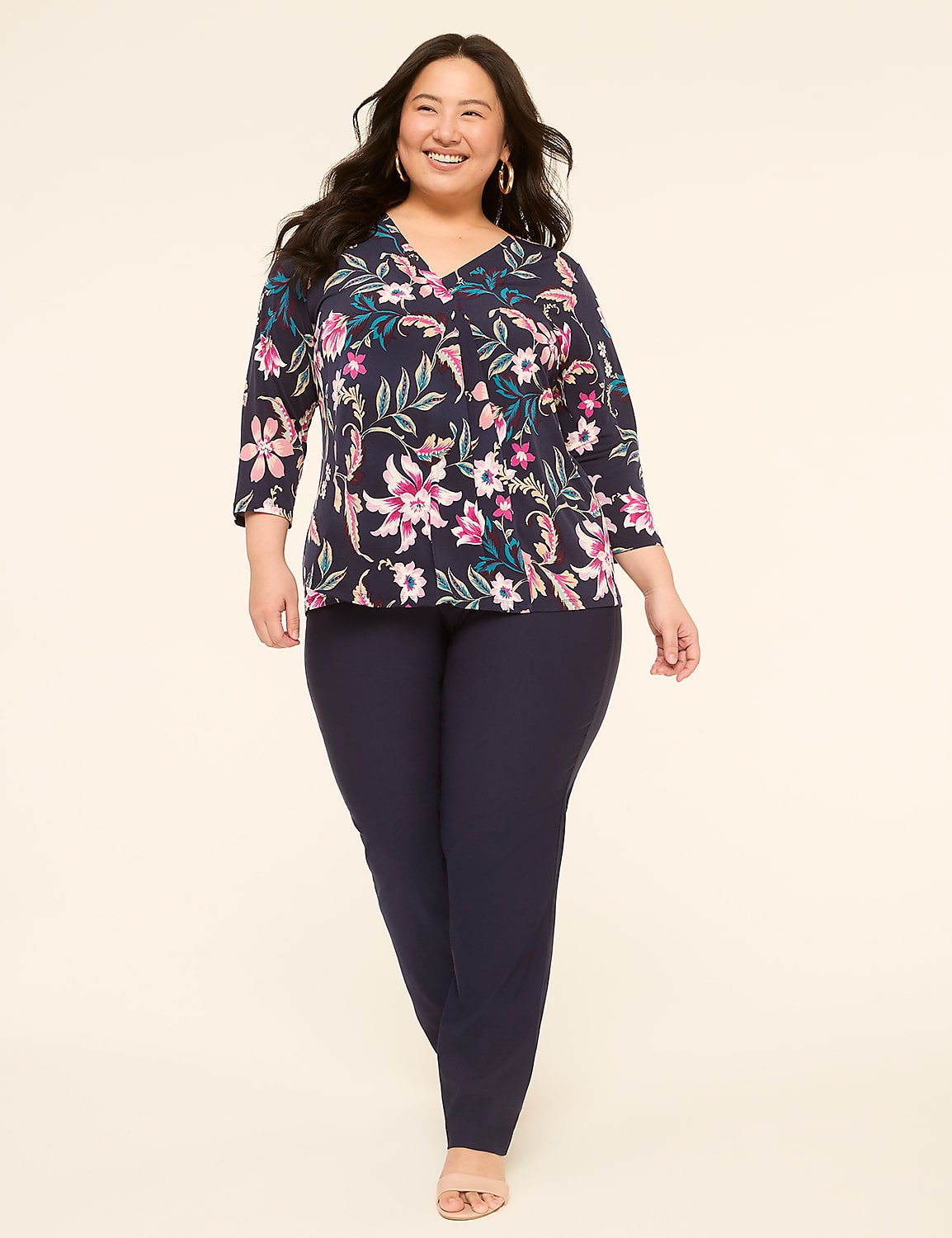 A smiling woman in a floral top and navy pants stands against a plain, light-colored background. Product Image 3
