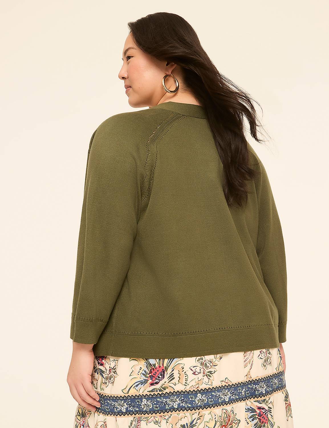 A woman in a green cardigan and patterned skirt stands against a plain, light-colored background. Product Image 2