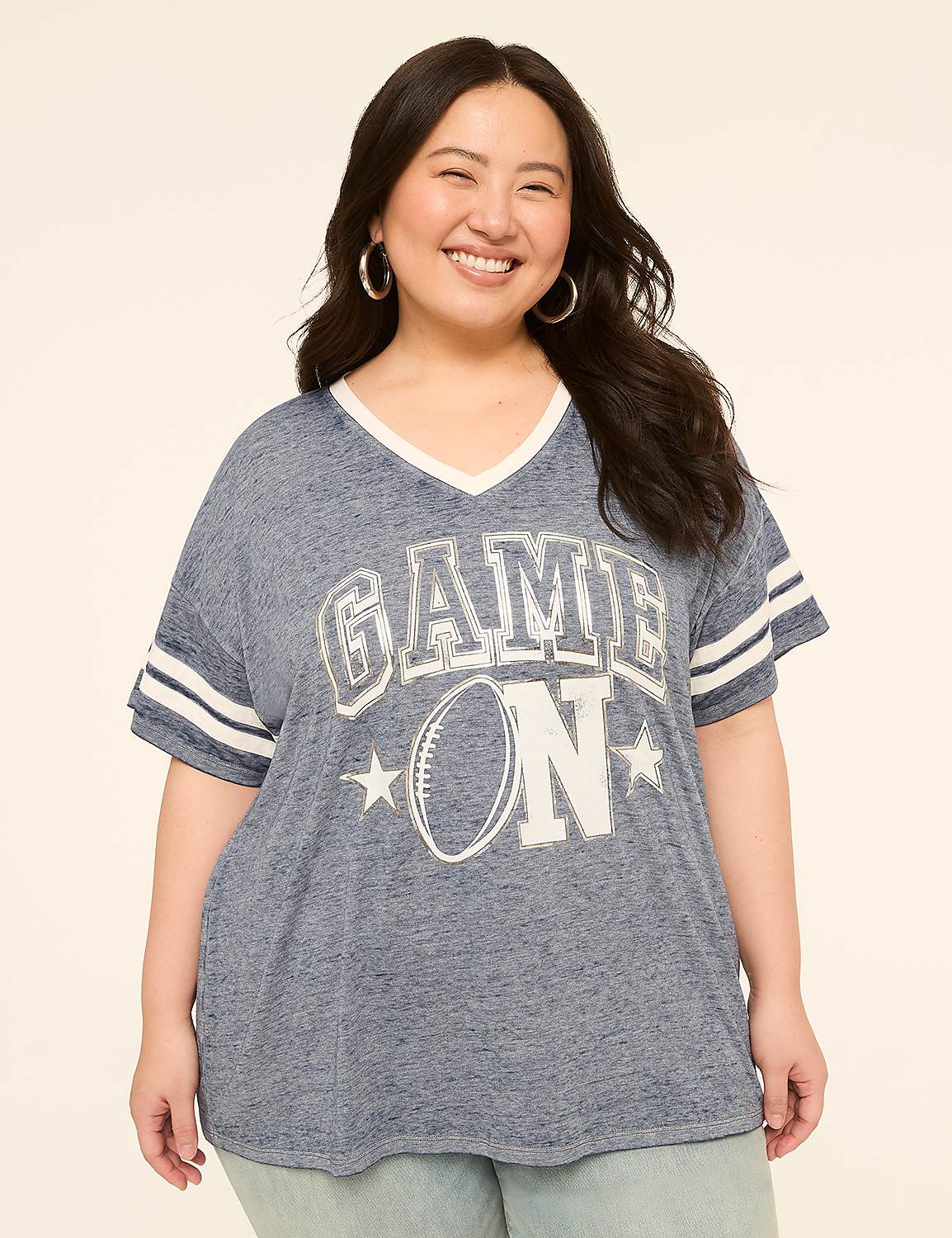 A smiling woman in a blue "GAME ON" t-shirt stands against a plain, light-colored background. Product Image 1