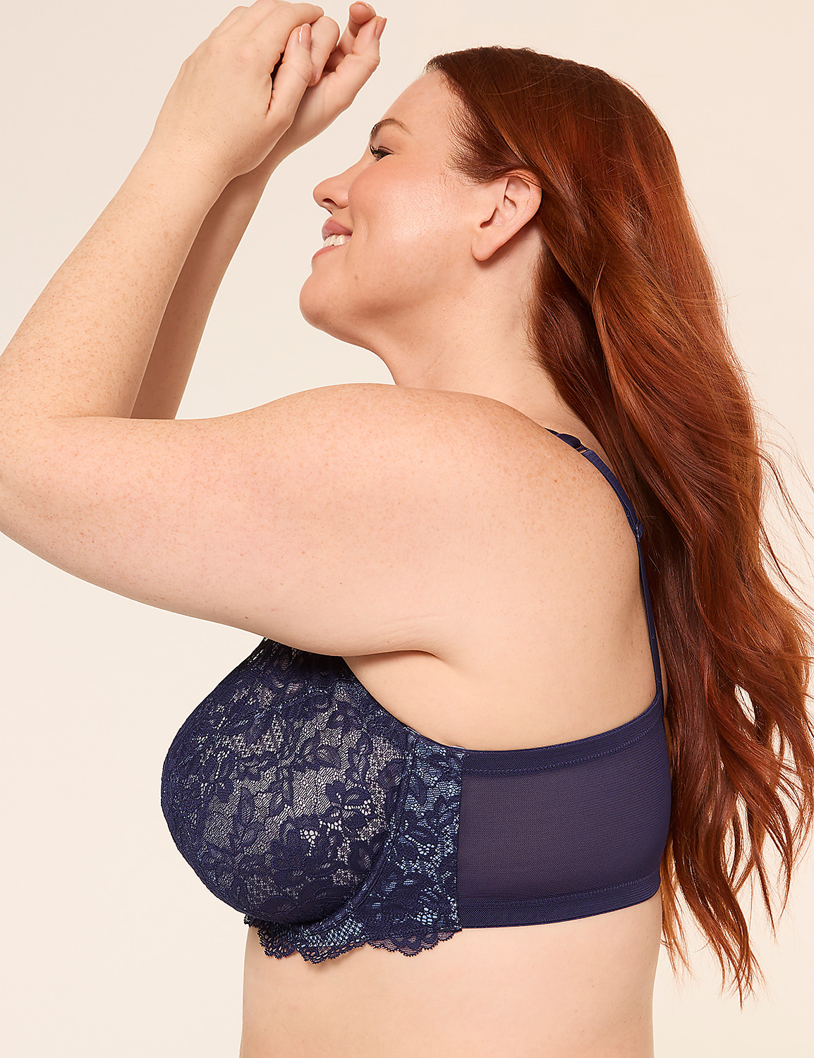 A woman with auburn hair smiles with her hands clasped above her head, wearing a navy lace bra against a plain, light background. Product Image 2