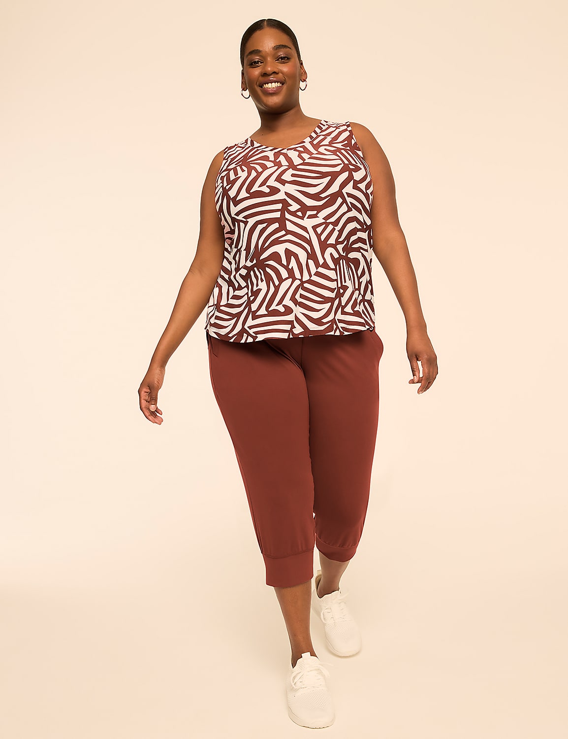 A smiling woman in a patterned top and maroon capri pants stands against a plain, light-colored background. Product Image 3