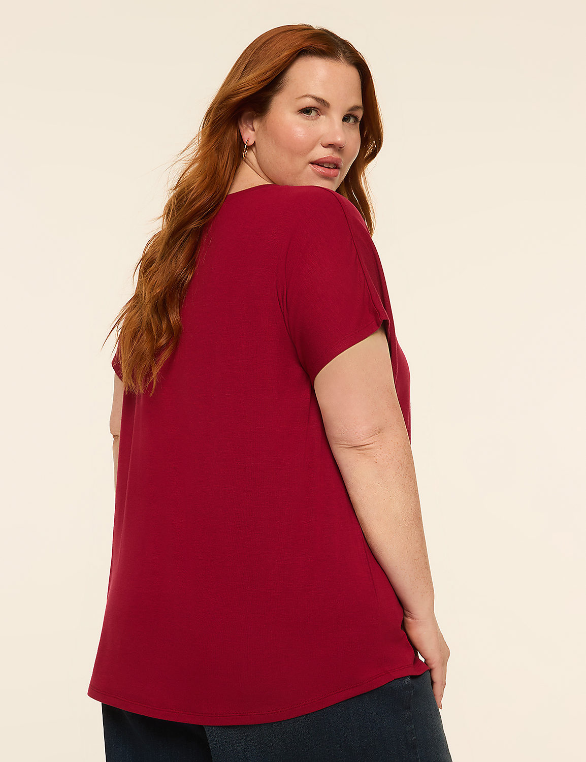 A woman with long red hair wearing a maroon top and blue jeans stands against a plain, light-colored background. Product Image 2