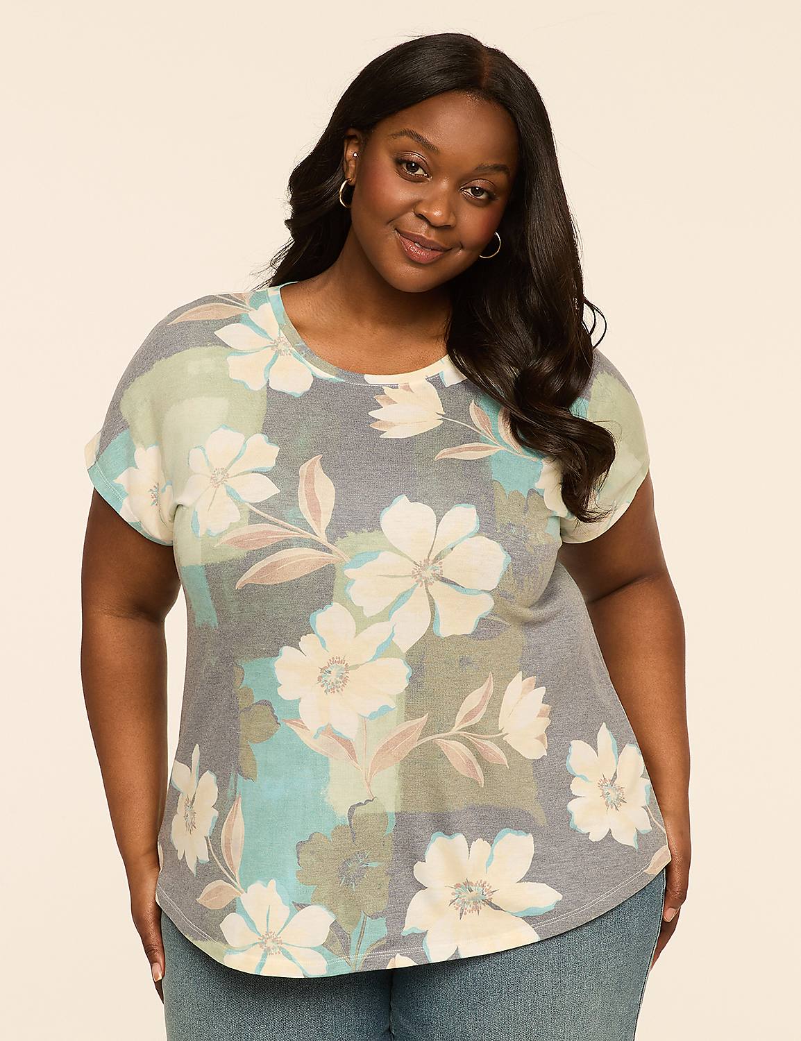A woman with dark hair and a floral print shirt stands against a plain, light-colored background. Product Image 1