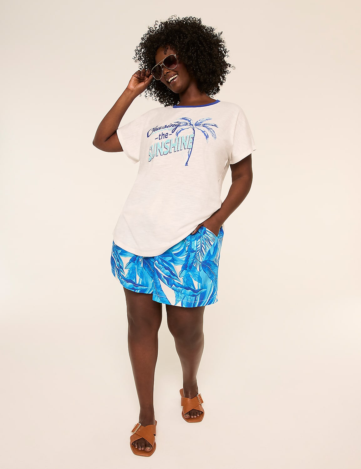 A smiling woman in a floral romper poses against a plain, light-colored background. Product Image 3