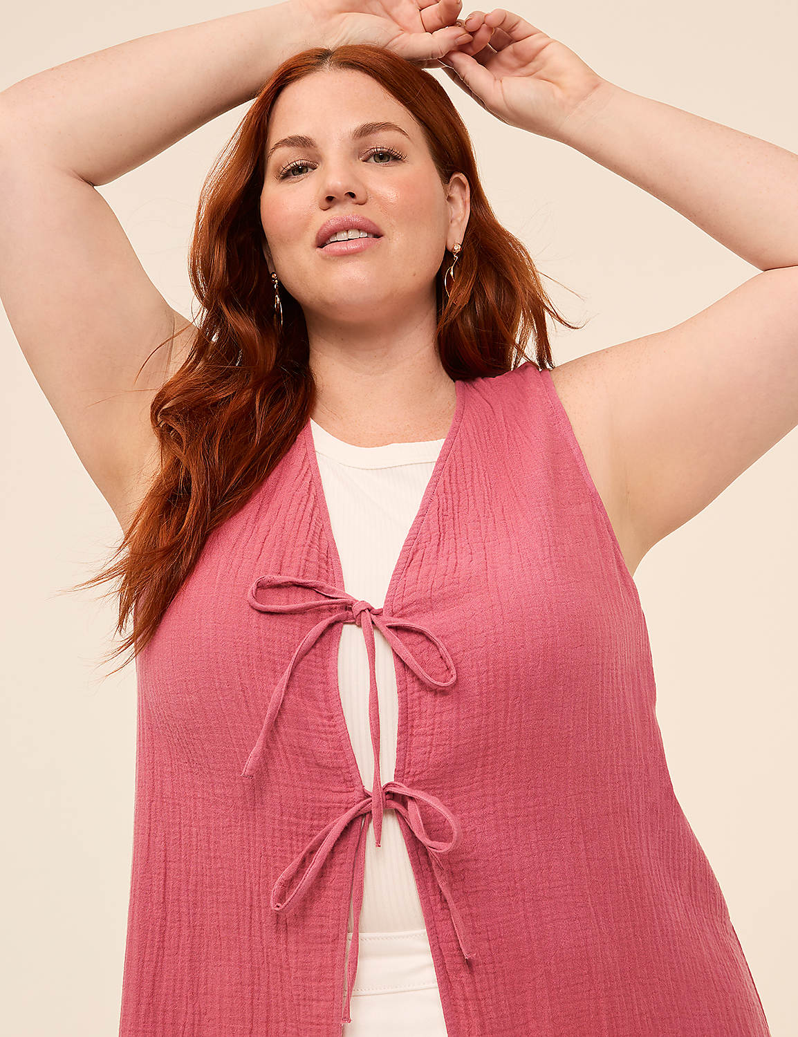 A woman with red hair and a pink vest is posing against a plain, light-colored background. Product Image 3