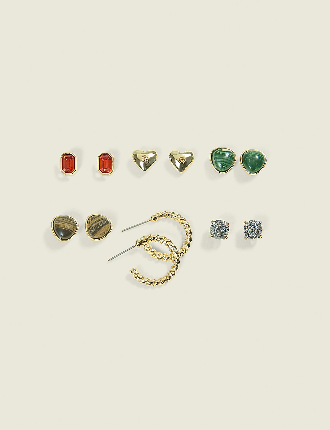 A collection of assorted earrings, including studs and hoops, are arranged on a plain, light-colored background. Product Image 1