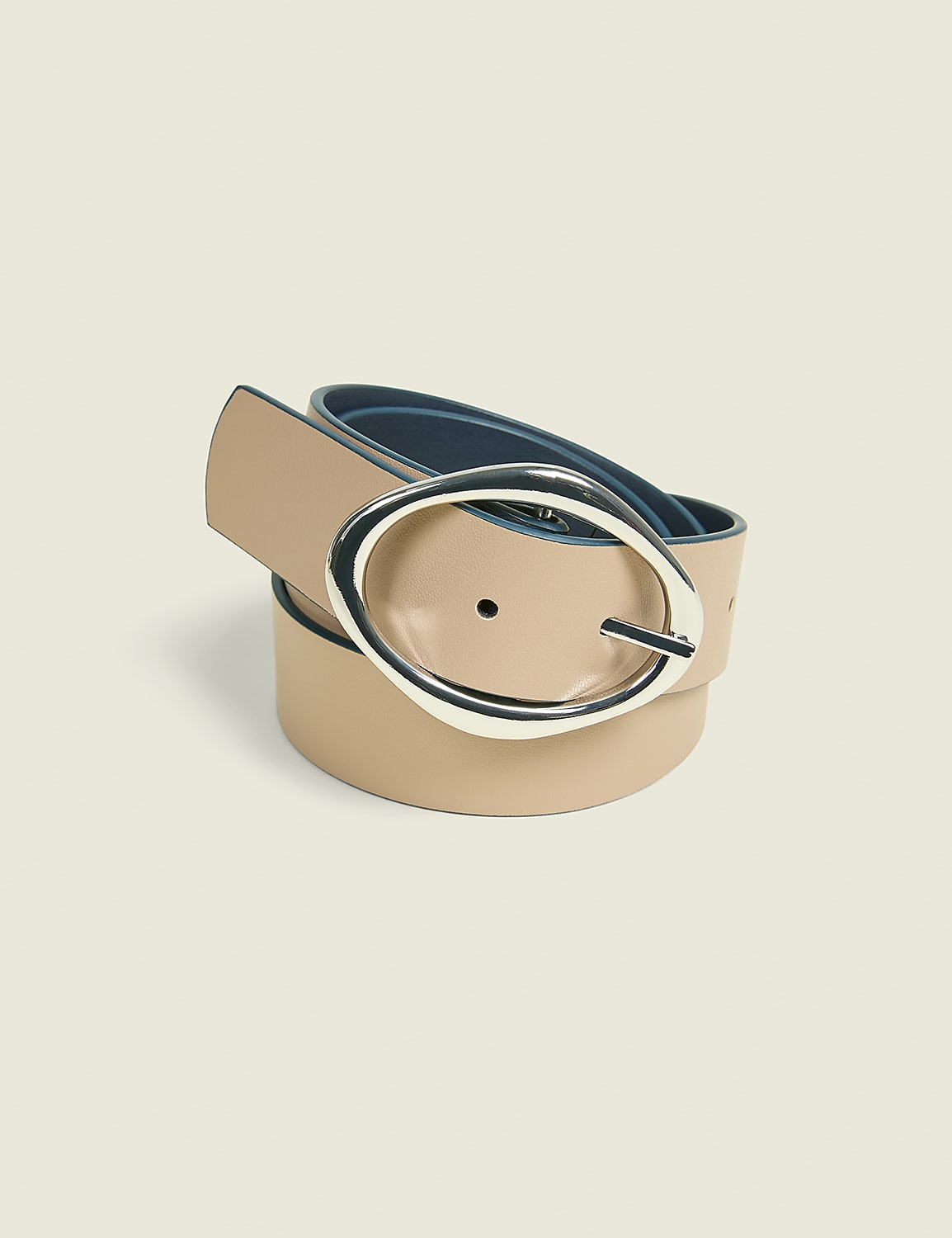 A beige leather belt with a silver oval buckle is coiled on a light beige background. Product Image 2