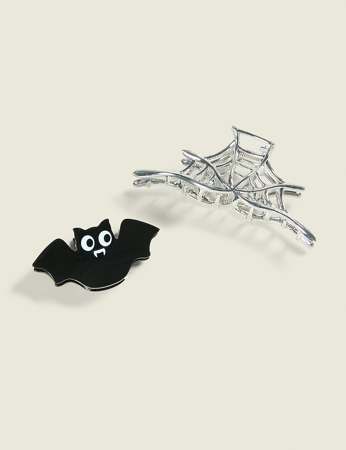 A black bat with wide eyes sits in the foreground next to a silver spiderweb on a plain background. Product Image 1