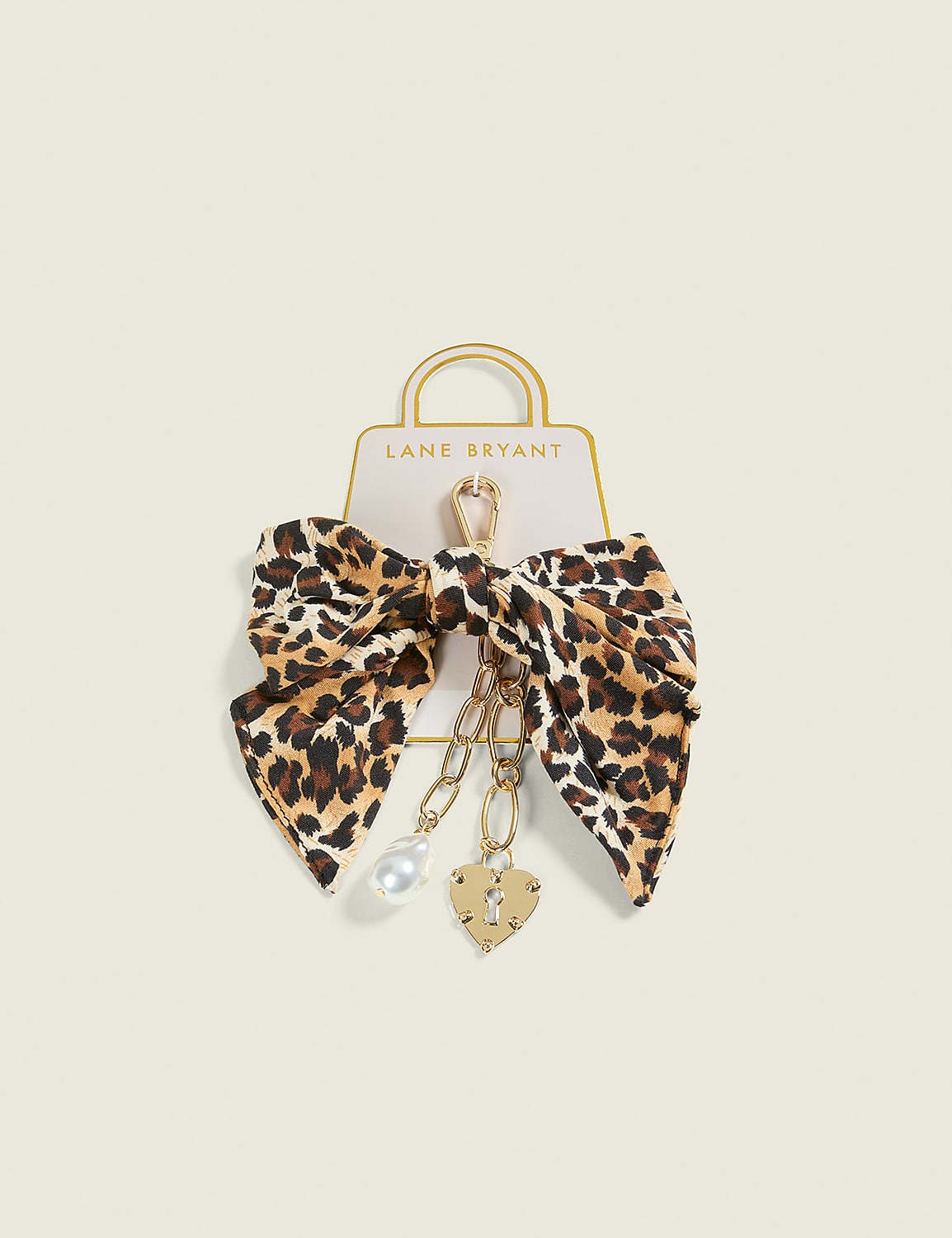 A leopard-print bow with dangling charms hangs from a Lane Bryant shopping bag tag against a pale, textured background. Product Image 1