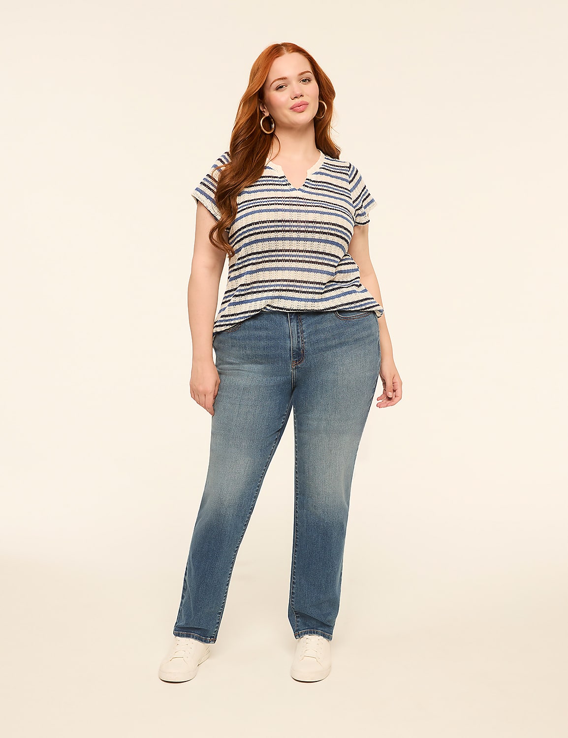A woman with red hair stands in the foreground wearing a striped shirt and jeans against a plain, light-colored background. Product Image 3