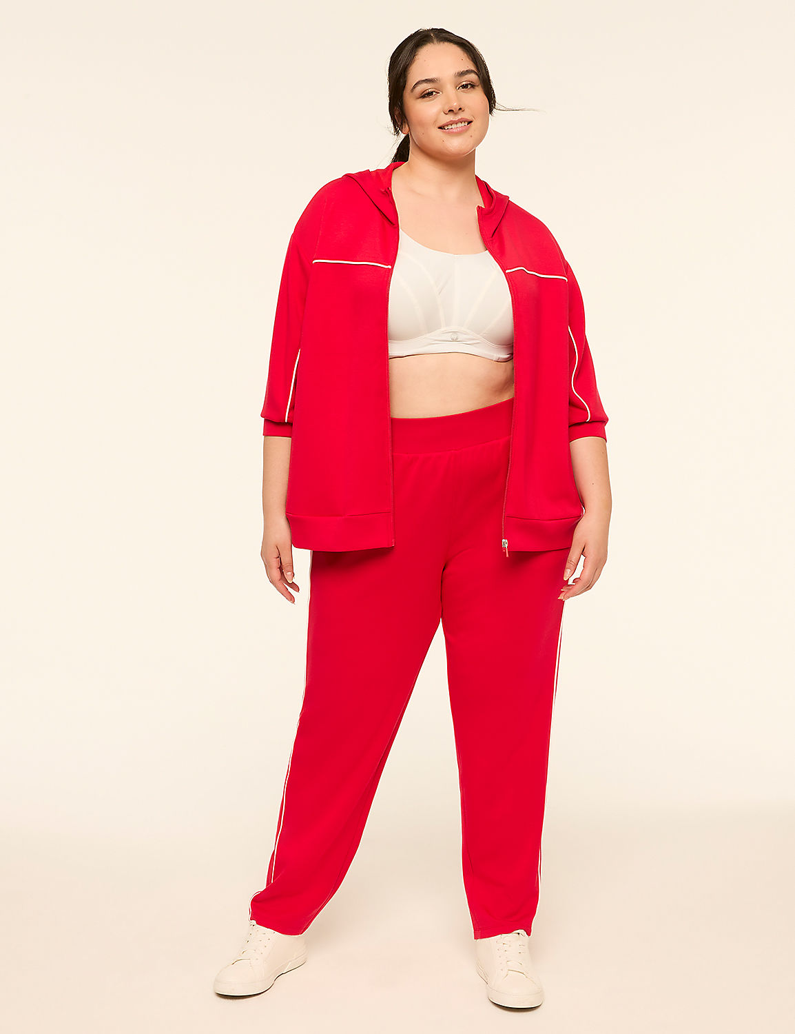 A smiling woman in a red tracksuit stands against a plain, light-colored background. Product Image 3