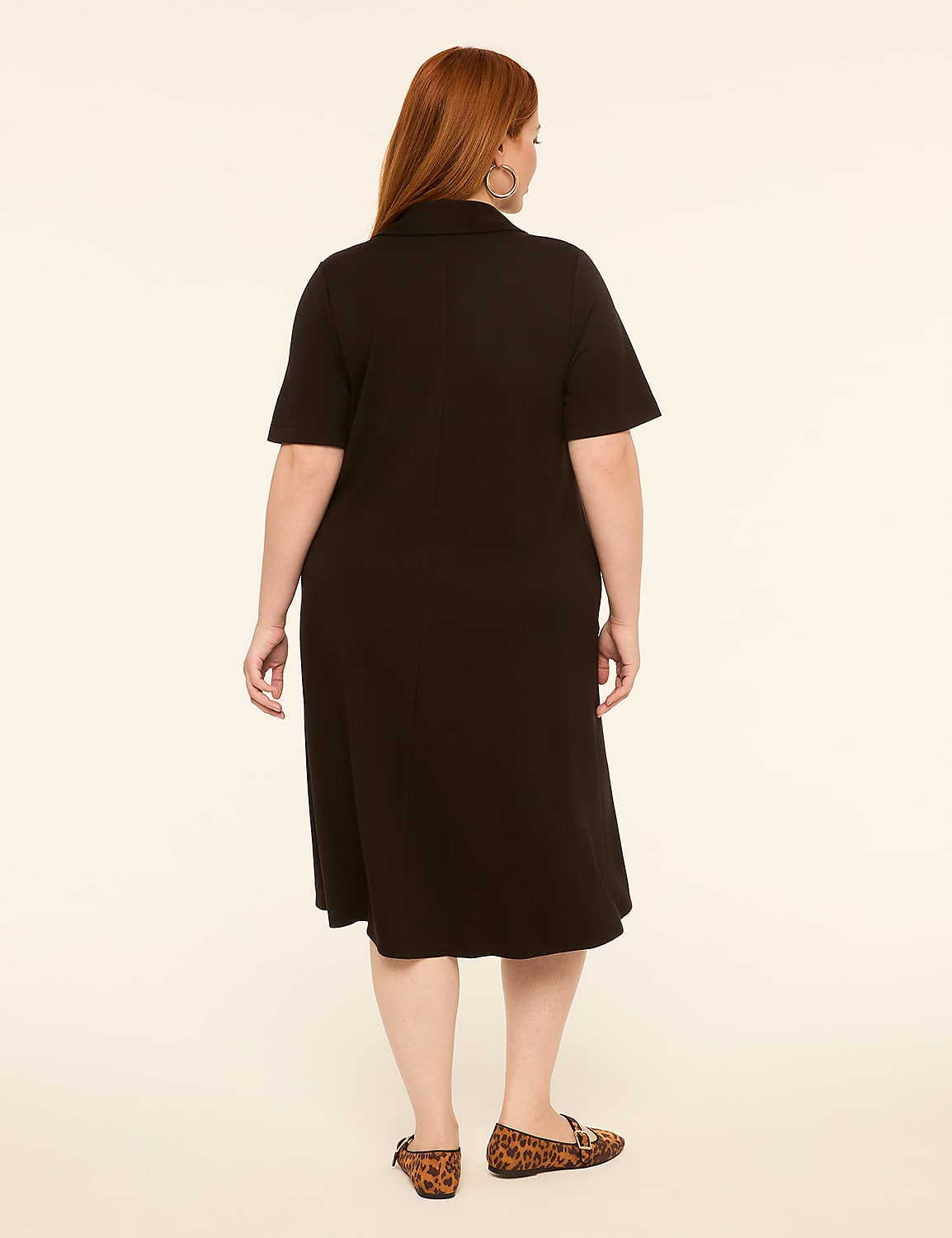 A woman in a black dress stands against a plain, light-colored background. Product Image 2