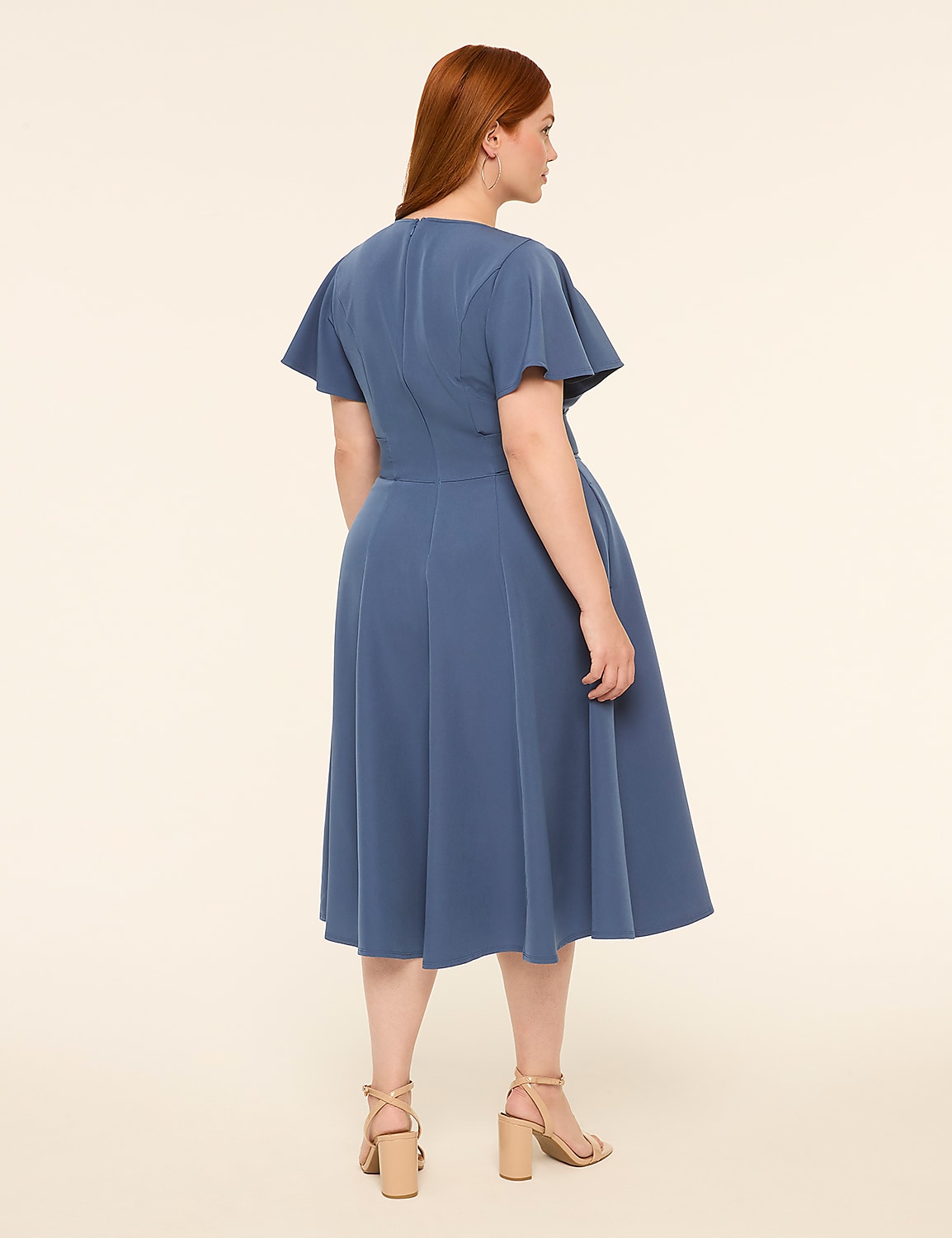 A woman in a blue dress stands against a plain, light-colored background. Product Image 2