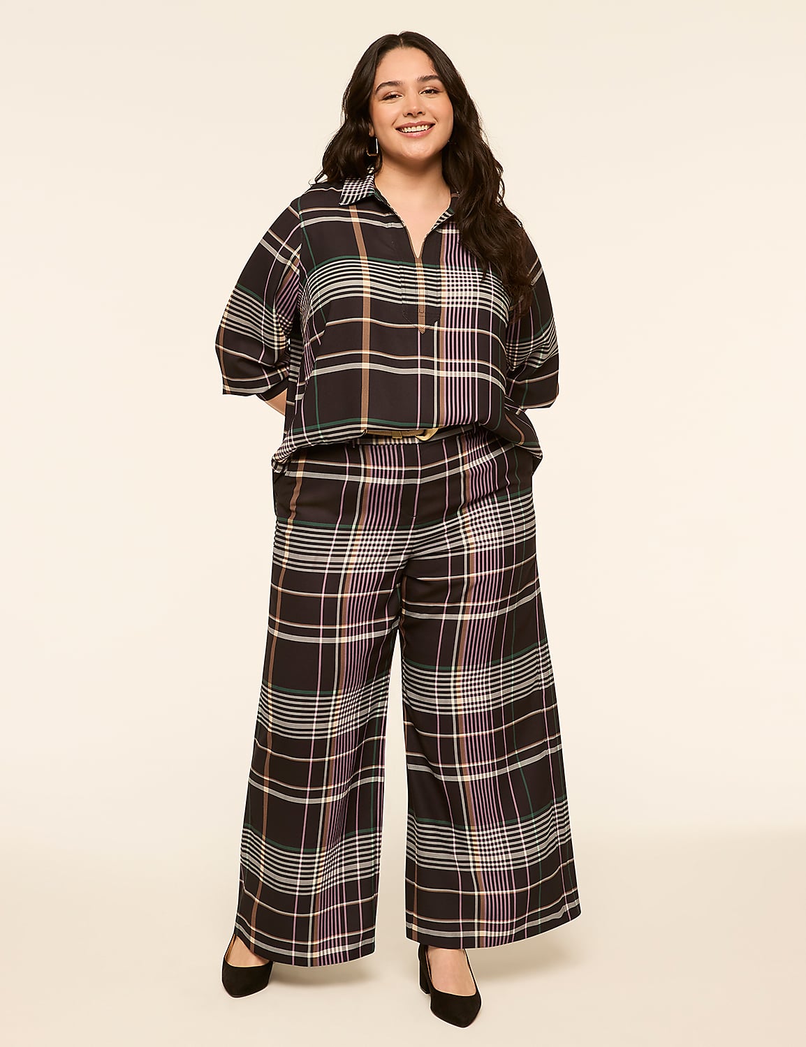 A young woman in a plaid outfit stands against a plain, light-colored background. Product Image 3
