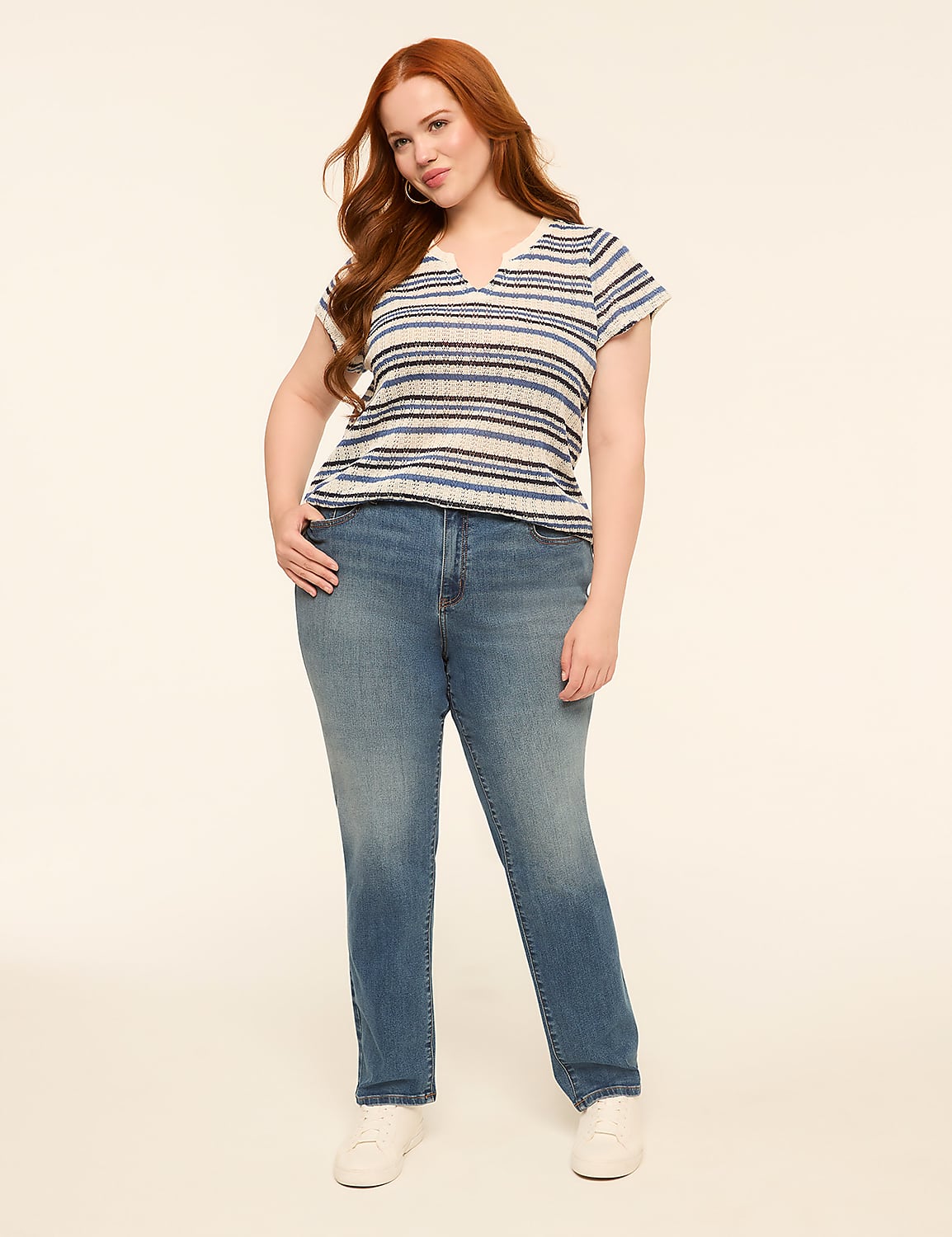 A woman with long red hair stands in the foreground wearing a striped shirt and jeans against a plain, light-colored background. Product Image 3