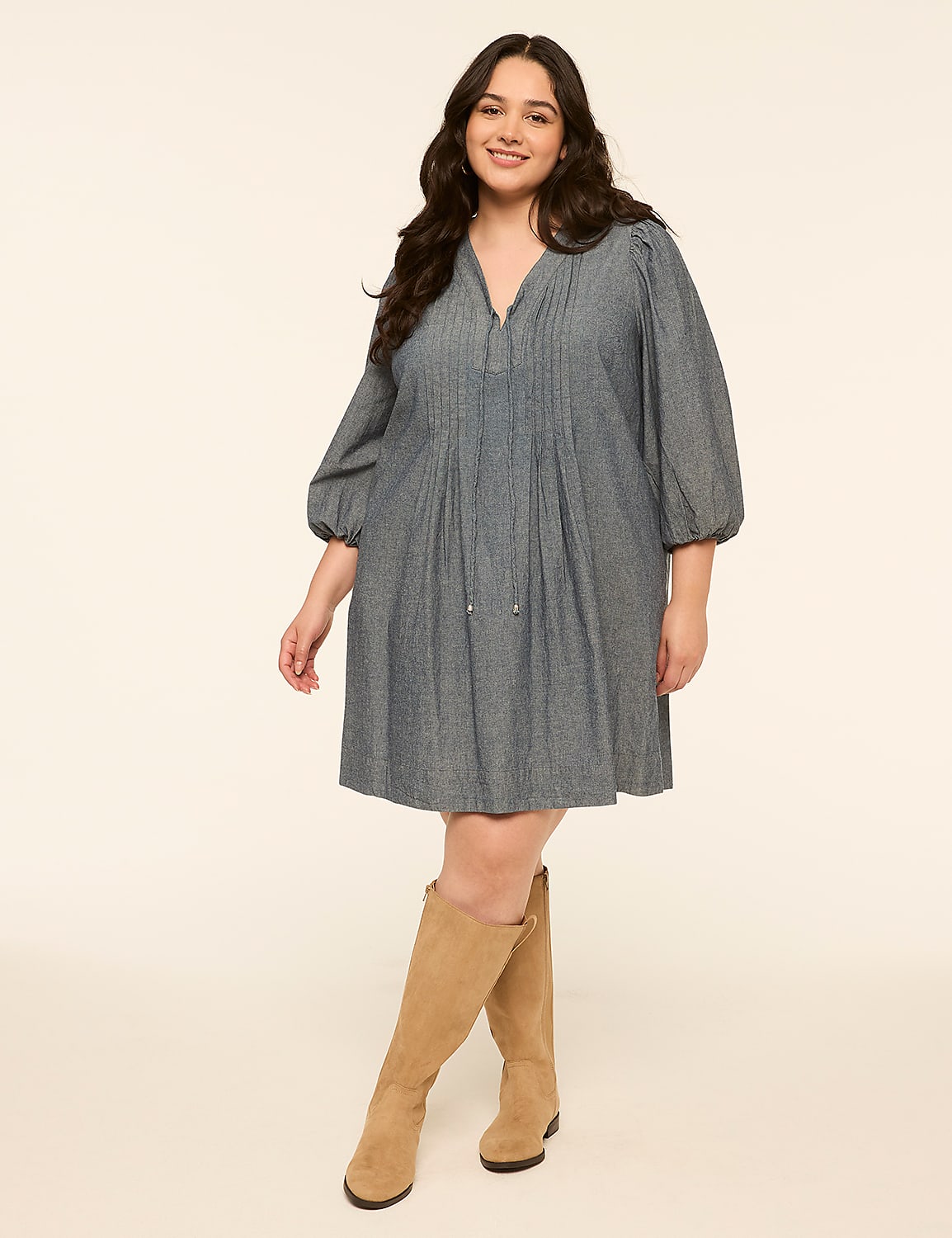 A smiling woman in a blue dress and tan boots stands against a plain, light-colored background. Product Image 1
