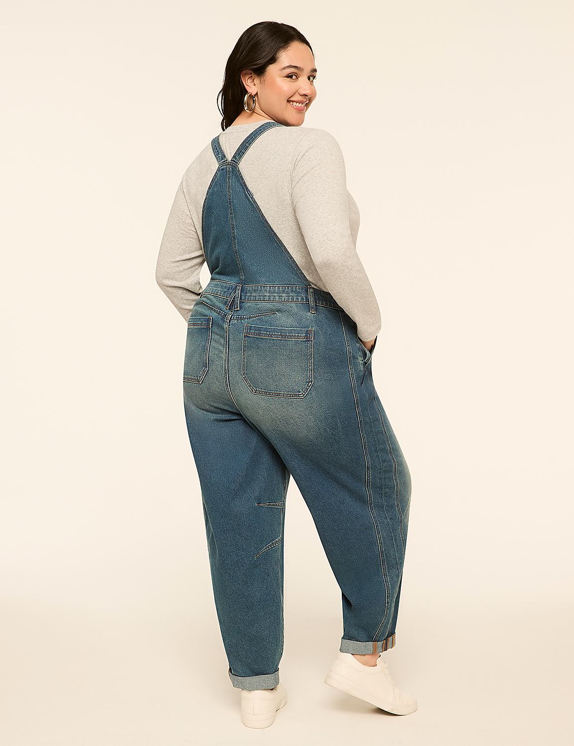 A woman in denim overalls stands against a plain, light-colored background. Product Image 2