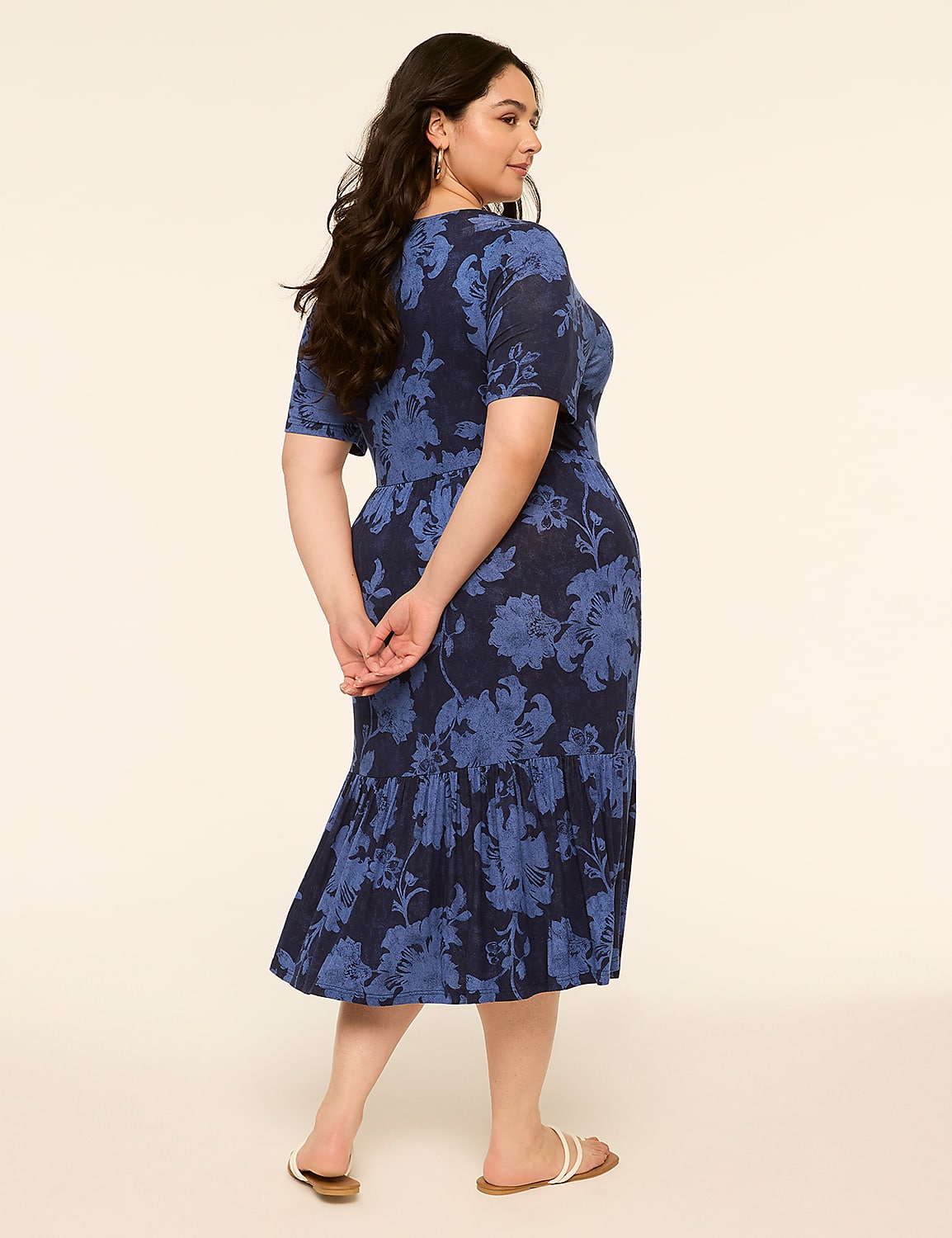 A woman in a blue floral dress stands with her back to the viewer against a plain, light-colored background. Product Image 2