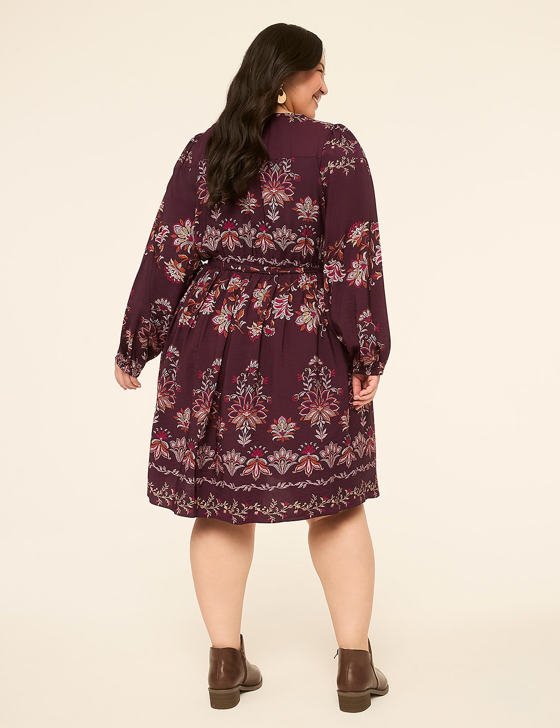 A woman in a patterned burgundy dress and brown boots stands against a plain cream background. Product Image 2