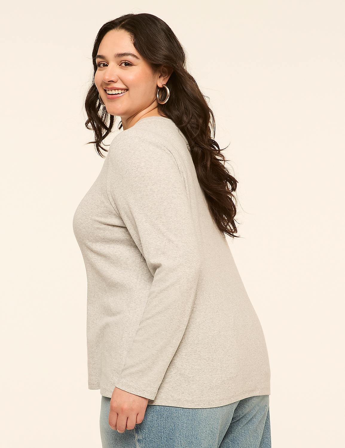 A smiling woman in a light gray long-sleeved shirt and blue jeans stands against a plain, light-colored background. Product Image 2