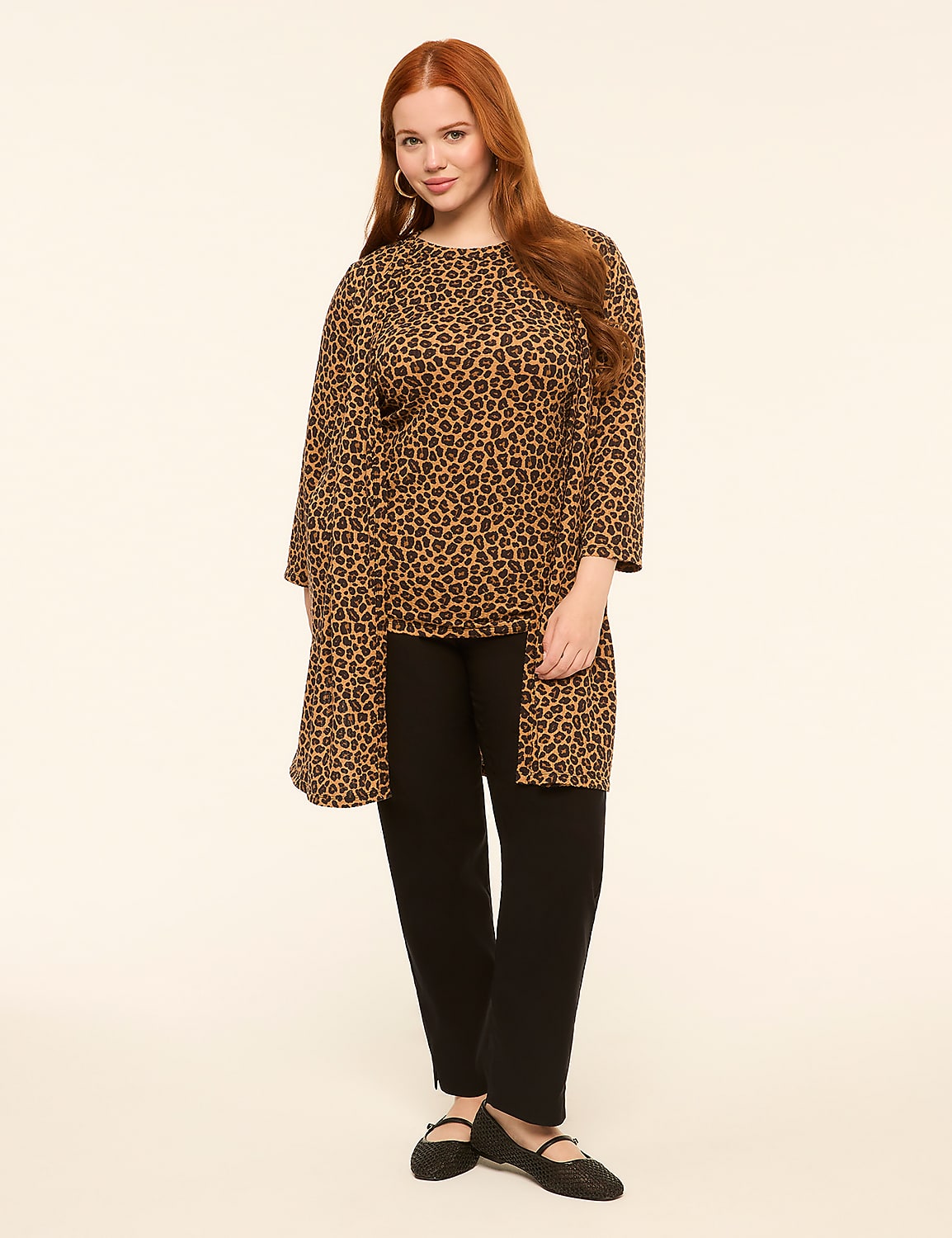 A woman with red hair stands in the foreground wearing a leopard print tunic over black pants, against a plain, light-colored background. Product Image 3