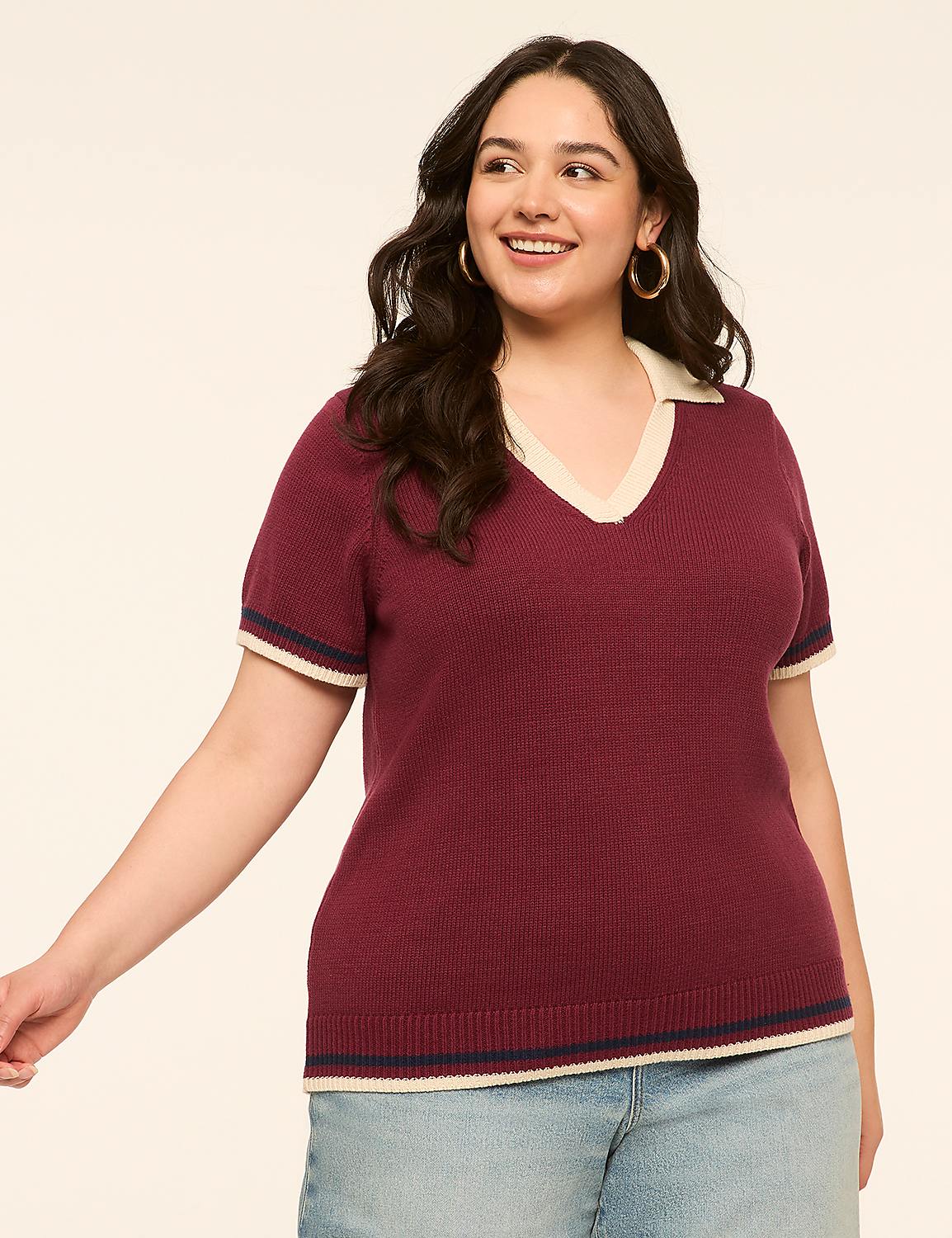 A smiling woman in a maroon collared shirt and denim shorts stands against a plain, light-colored background. Product Image 1