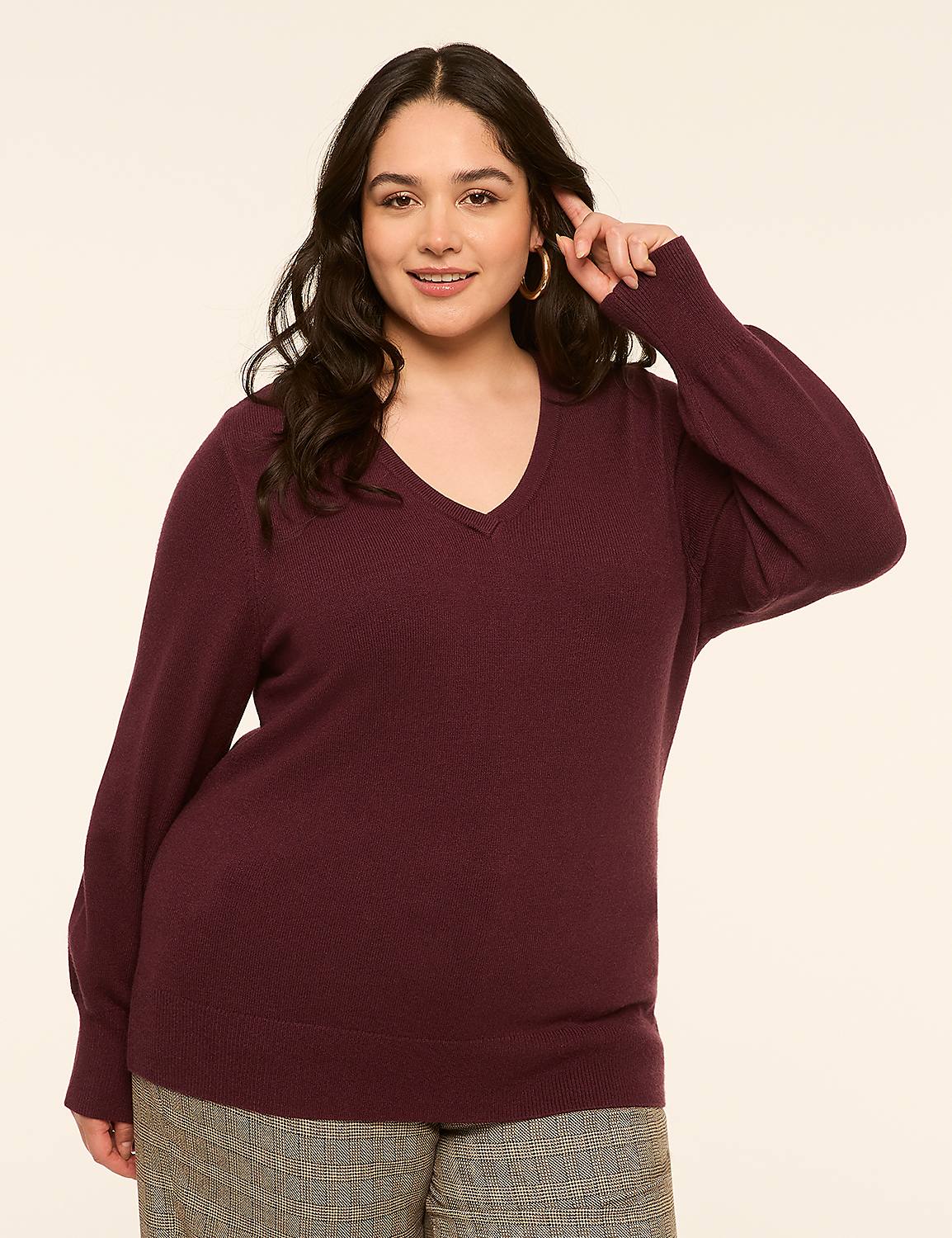 A woman in a burgundy v-neck sweater and plaid pants poses against a plain, light-colored background. Product Image 1