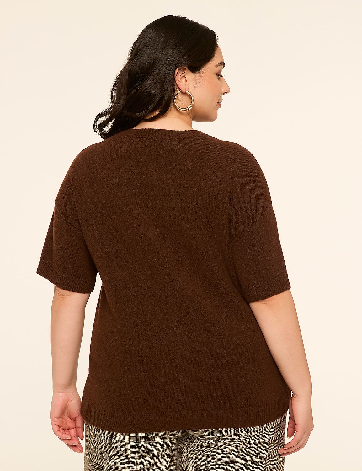 A woman in a brown sweater and patterned pants stands against a plain, light-colored background. Product Image 2