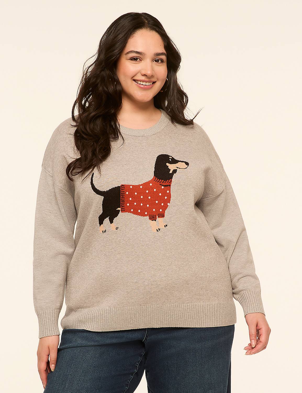 A smiling woman in a grey sweater with a dachshund graphic stands against a plain, light-colored background. Product Image 1