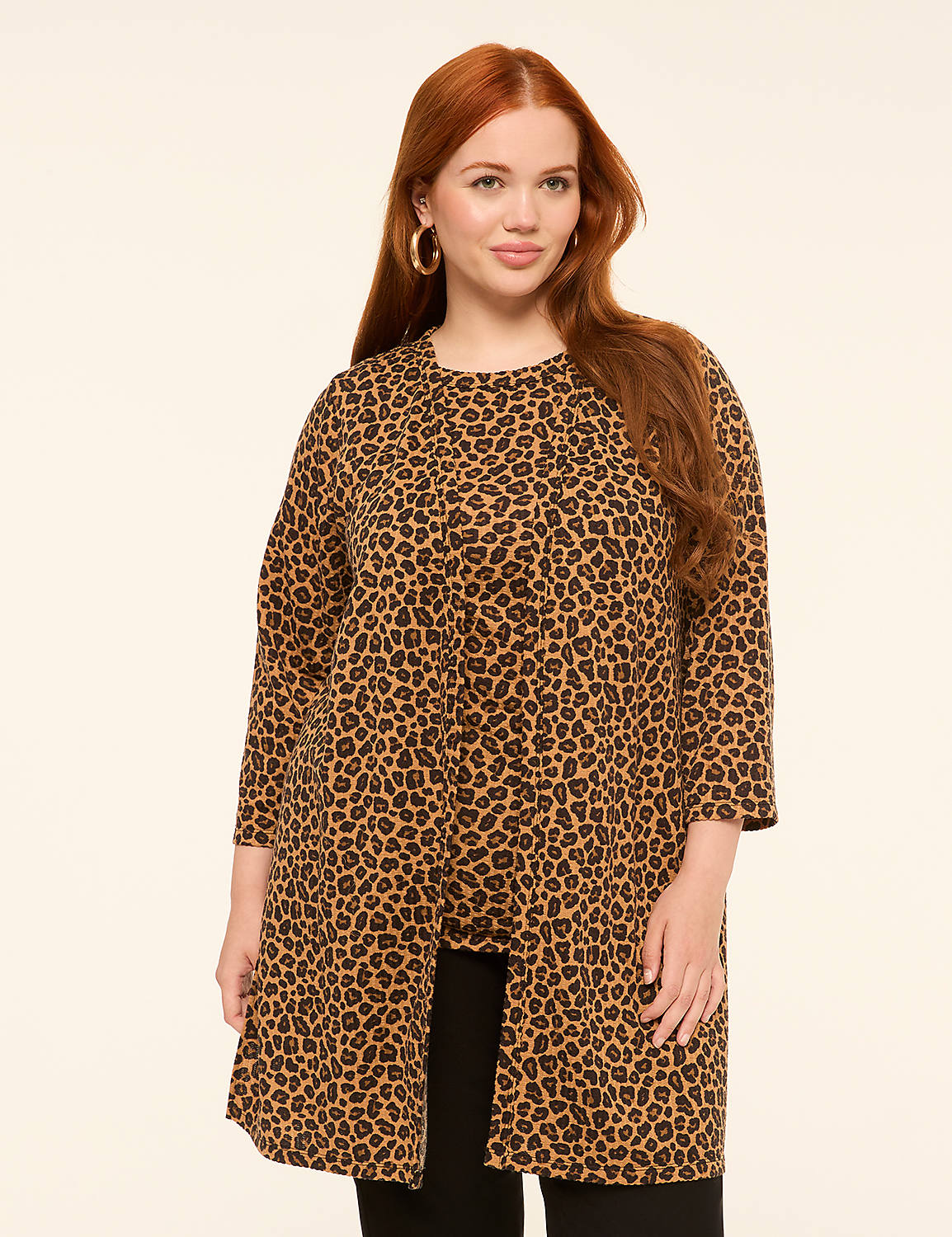 A woman with long red hair and large hoop earrings stands in the foreground wearing a leopard print jacket over black pants, against a plain, light-colored background. Product Image 1