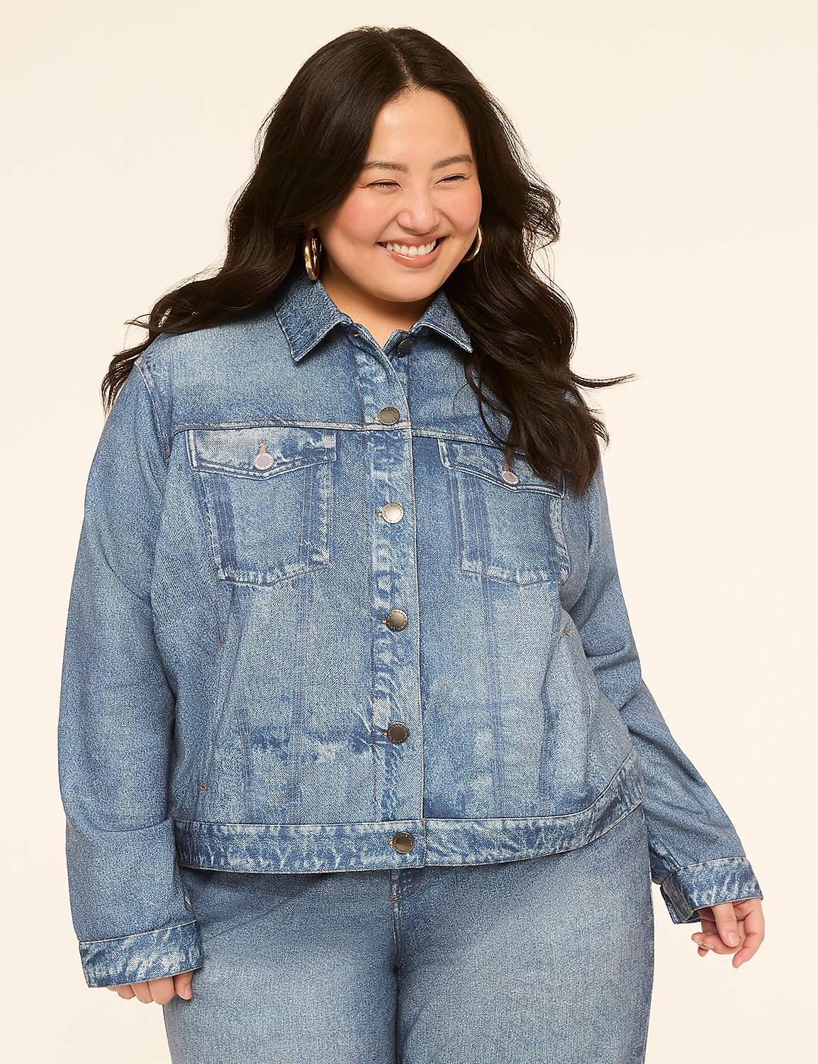 A smiling woman in a denim jacket and jeans stands against a plain, light-colored background. Product Image 1