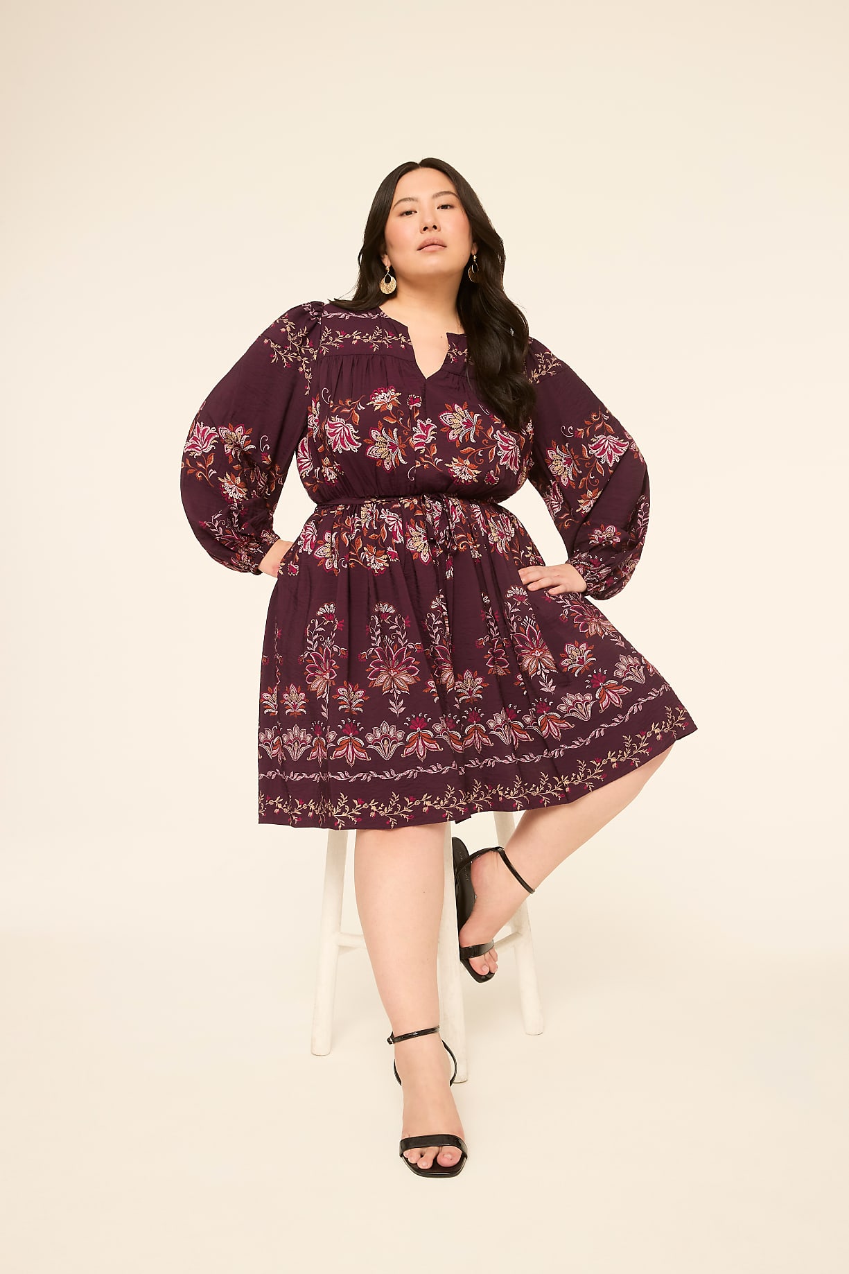 A woman in a floral print dress sits on a white stool against a plain, light-colored background. Product Image 4