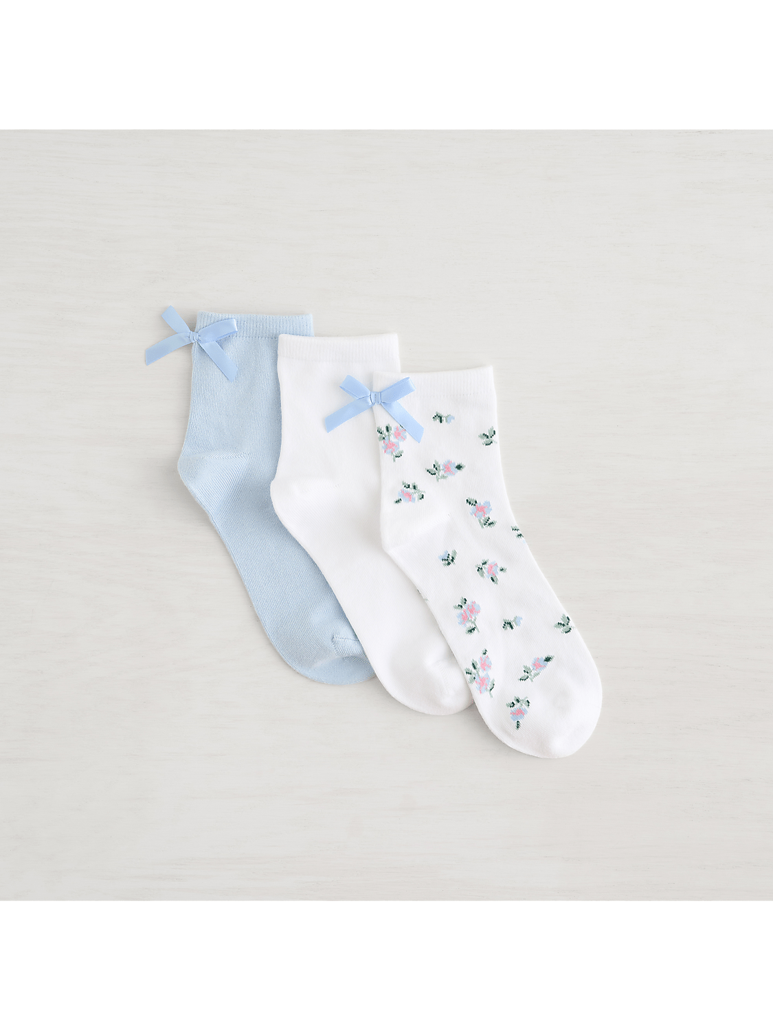 Three pairs of ankle socks, two solid pastel colors and one floral pattern, are arranged on a light, textured background. Product Image 3