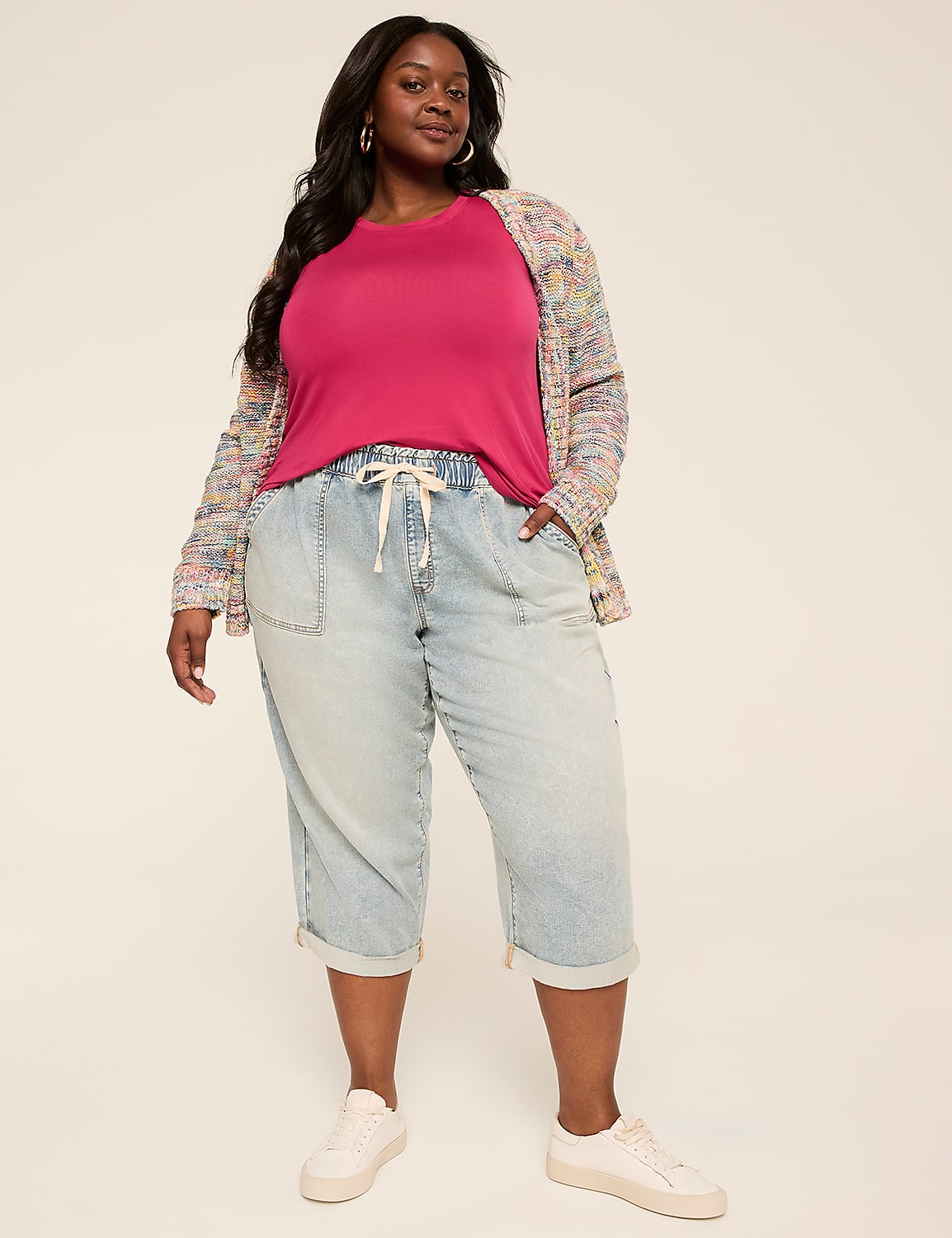 A woman in a pink top, a colorful cardigan, and light-wash capri pants stands against a plain, light-colored background. Product Image 3