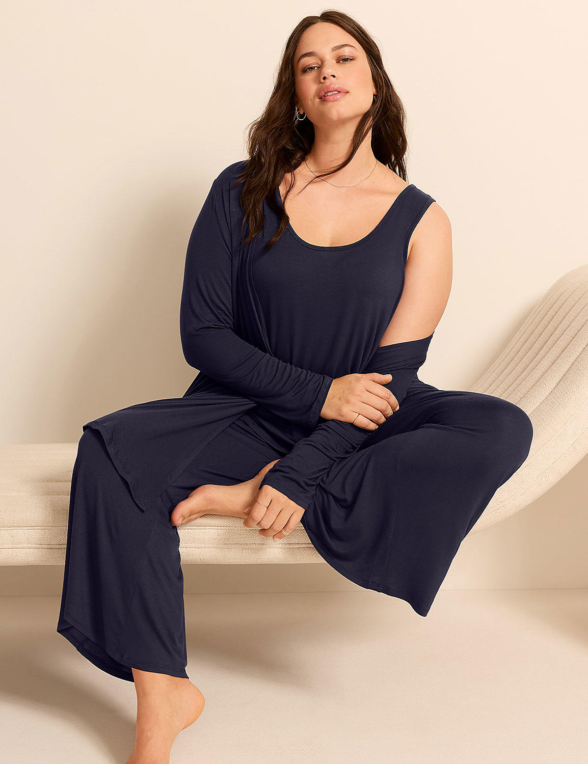 A woman in a navy blue loungewear set sits on a cream-colored chaise lounge against a plain white background. Product Image 5