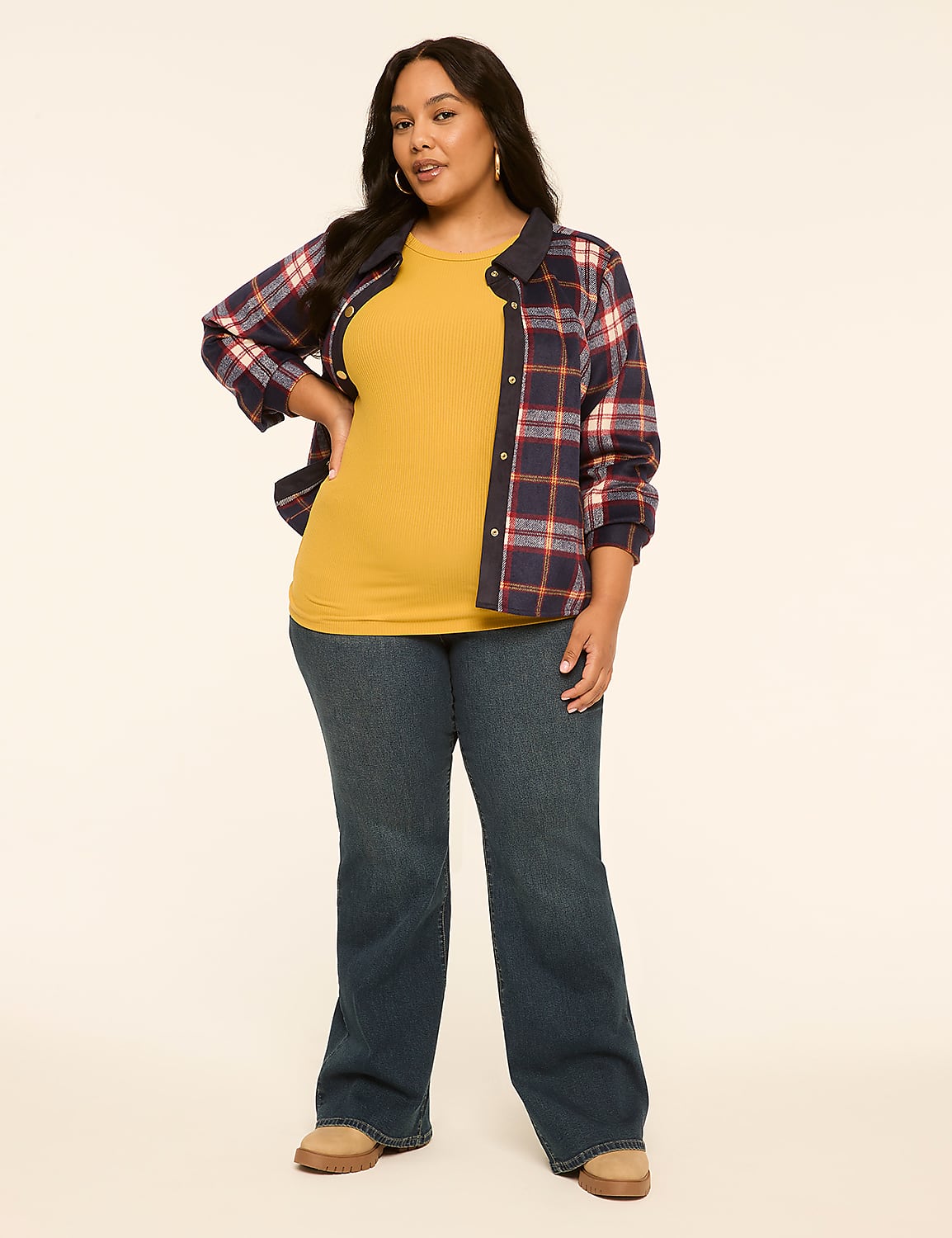 A woman in a yellow top, open plaid shirt, and blue jeans stands against a plain, light-colored background. Product Image 3