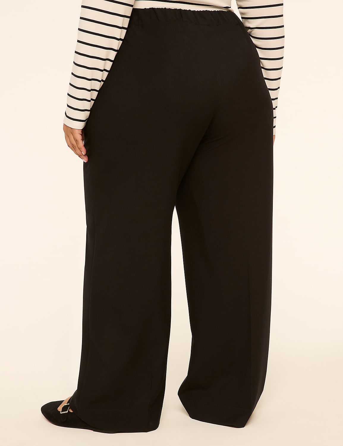 A person wearing black wide-leg pants and a striped shirt stands against a plain, light-colored background. Product Image 2