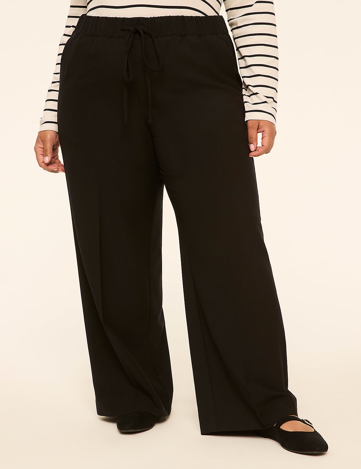 A person in black wide-leg pants and a striped shirt stands against a plain, light-colored background. Product Image 1