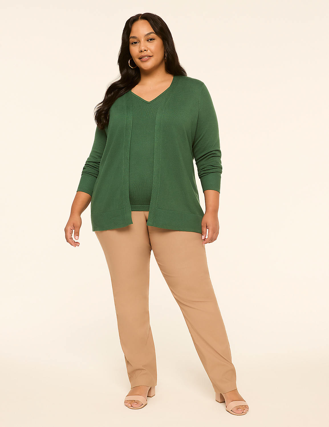 A woman in a green cardigan and tan pants stands against a plain, light-colored background. Product Image 3