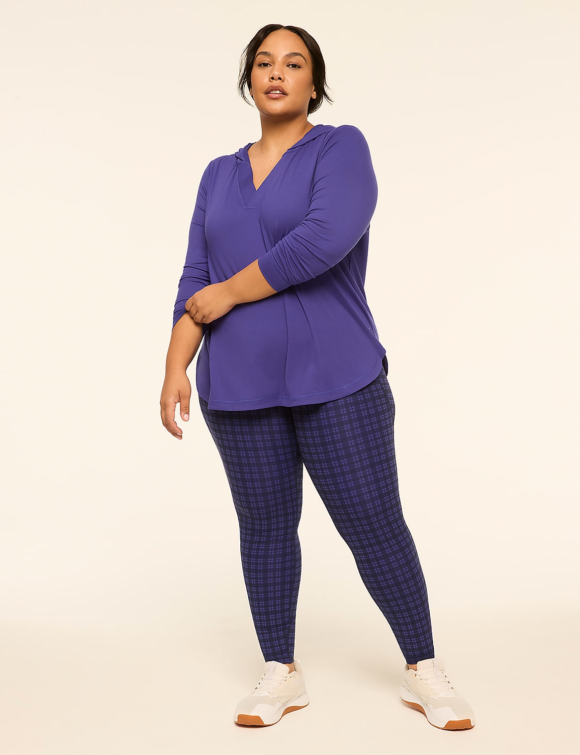 A woman in a purple hooded top and patterned leggings stands against a plain, light-colored background. Product Image 3