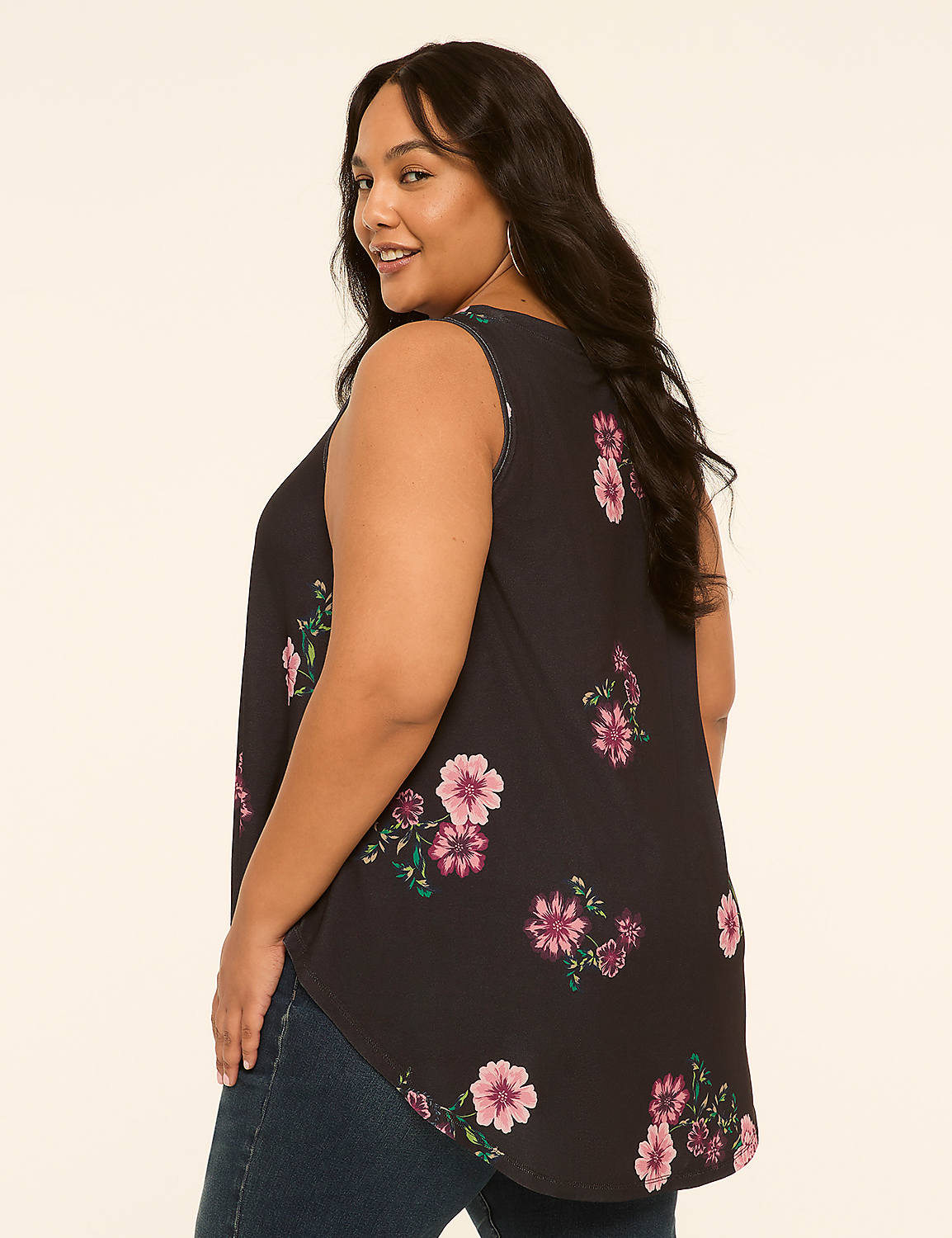 A woman in a floral tank top and jeans stands against a plain, light-colored background. Product Image 2