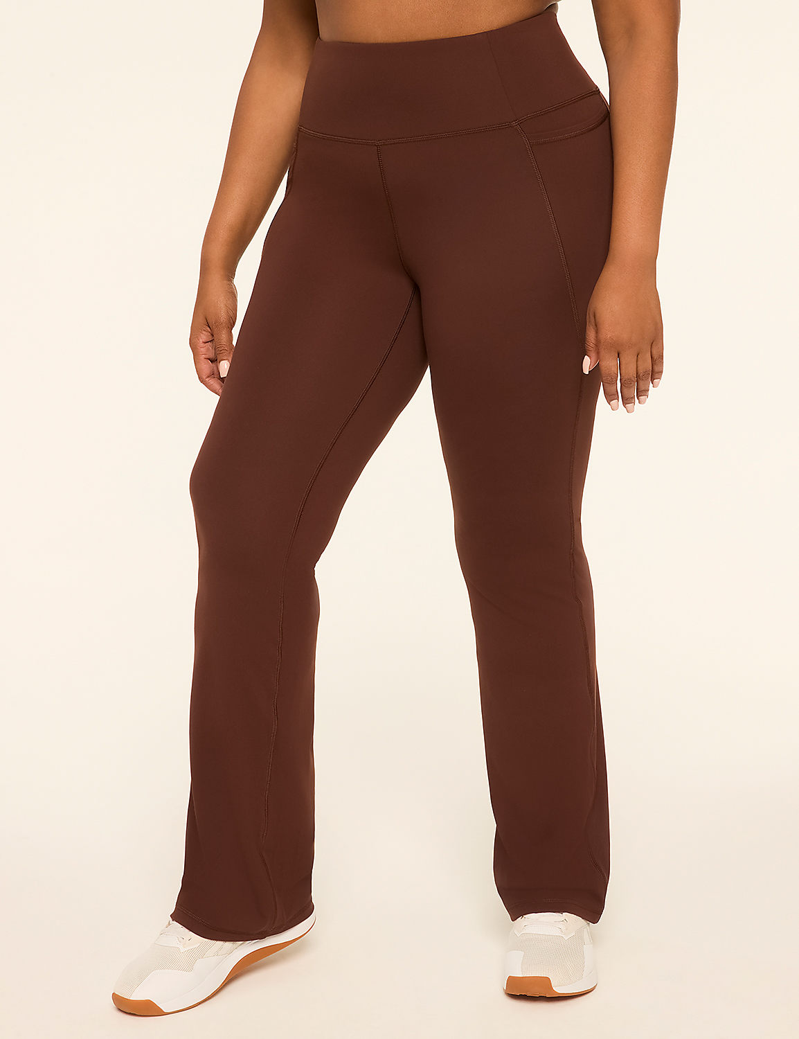 A person in brown flared yoga pants and white sneakers stands against a plain, light-colored background. Product Image 1